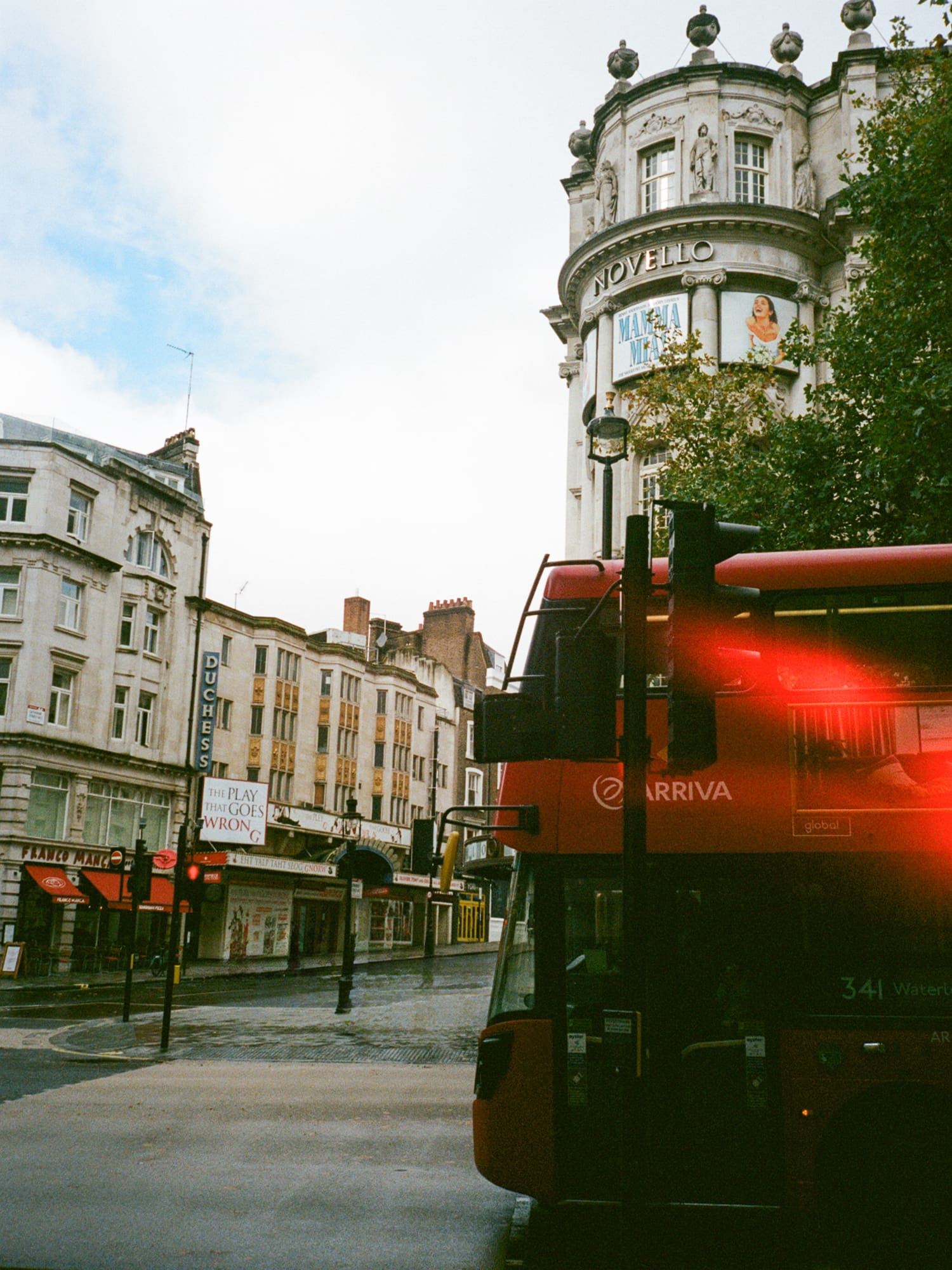 a red double decker bus on a street in a city