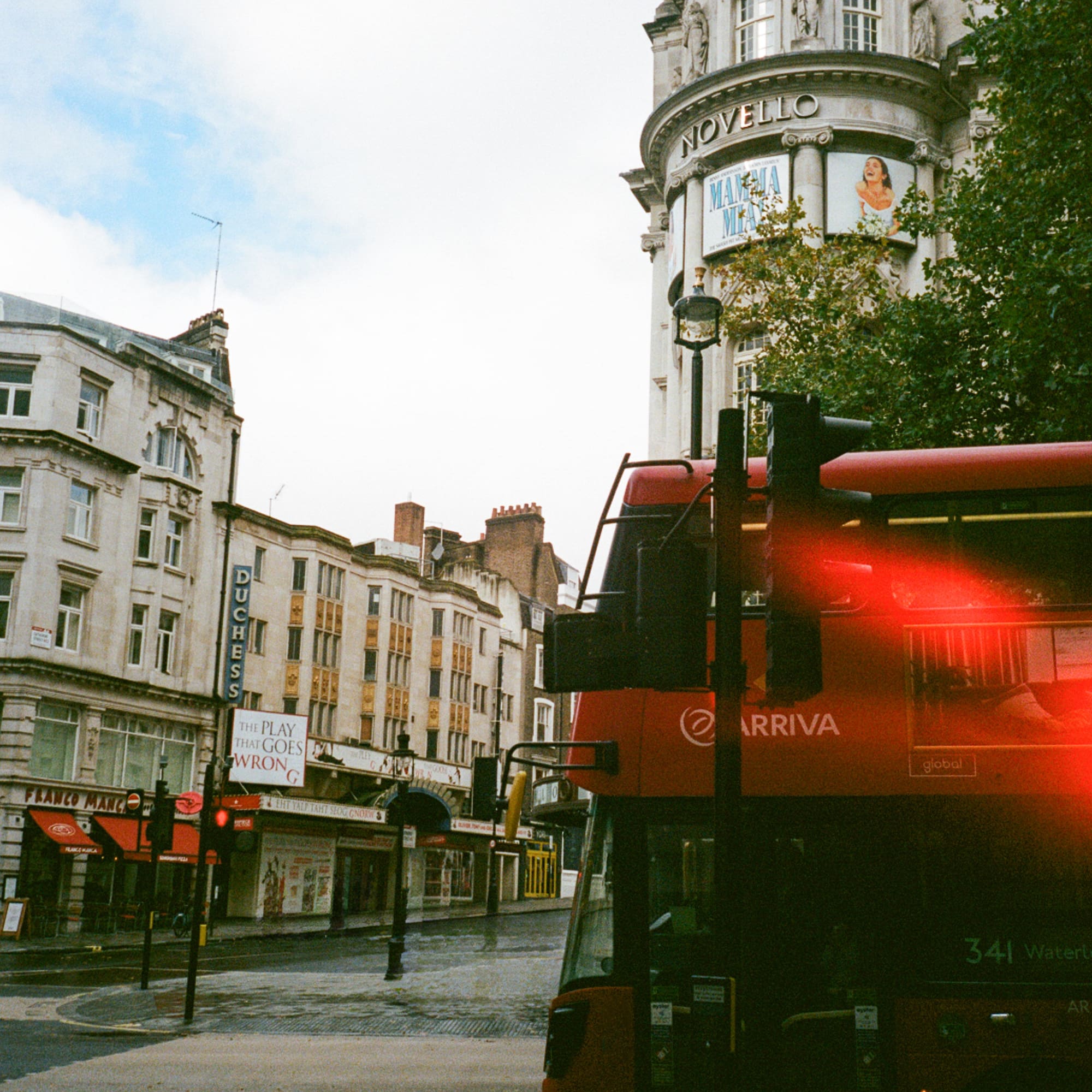 a red double decker bus on a street in a city