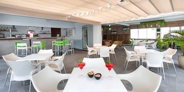 a room with tables and chairs and a bar