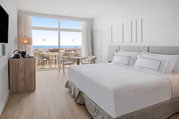 a bedroom with a large window overlooking the ocean