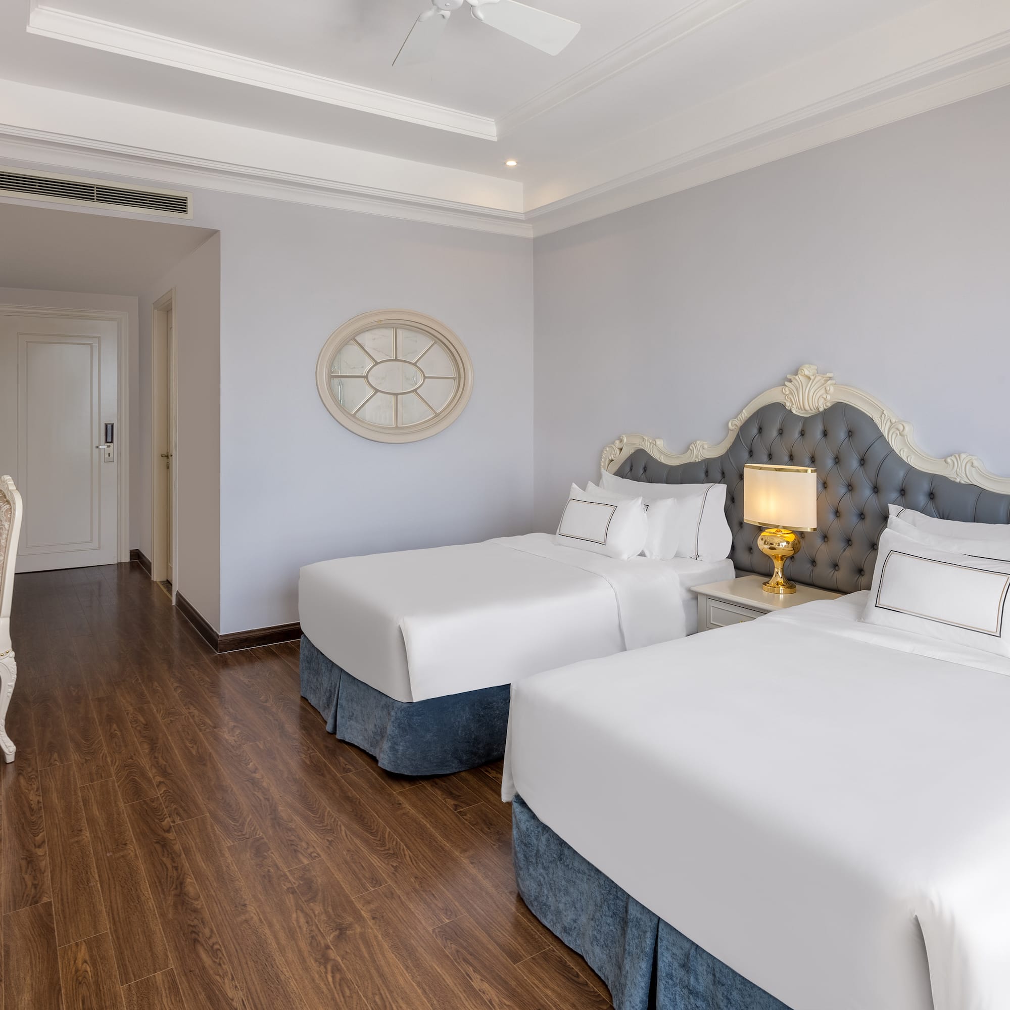 a room with two beds and a wood floor