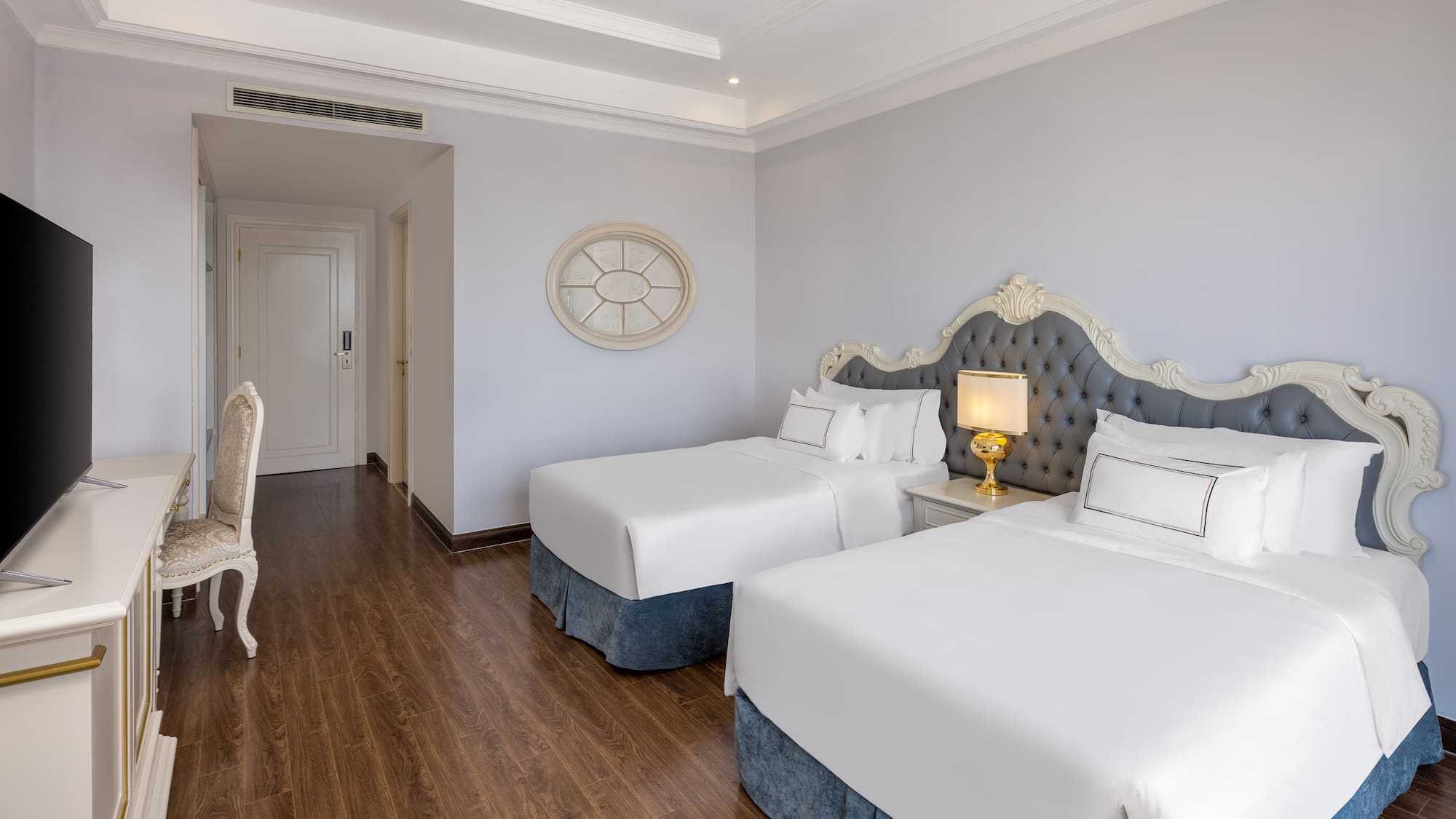 a room with two beds and a wood floor