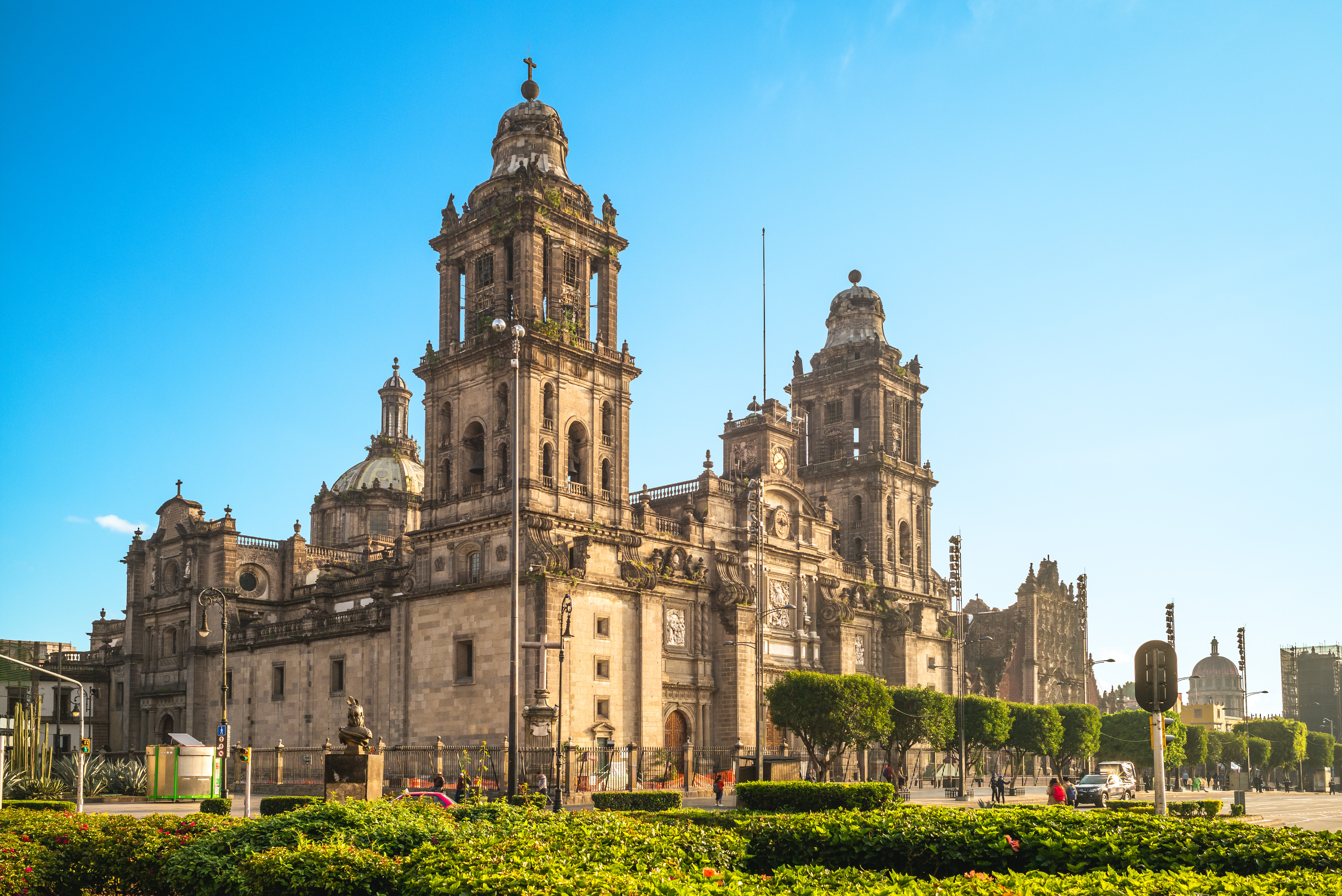 a large stone building with Mexico City Metropolitan Cathedral and a garden