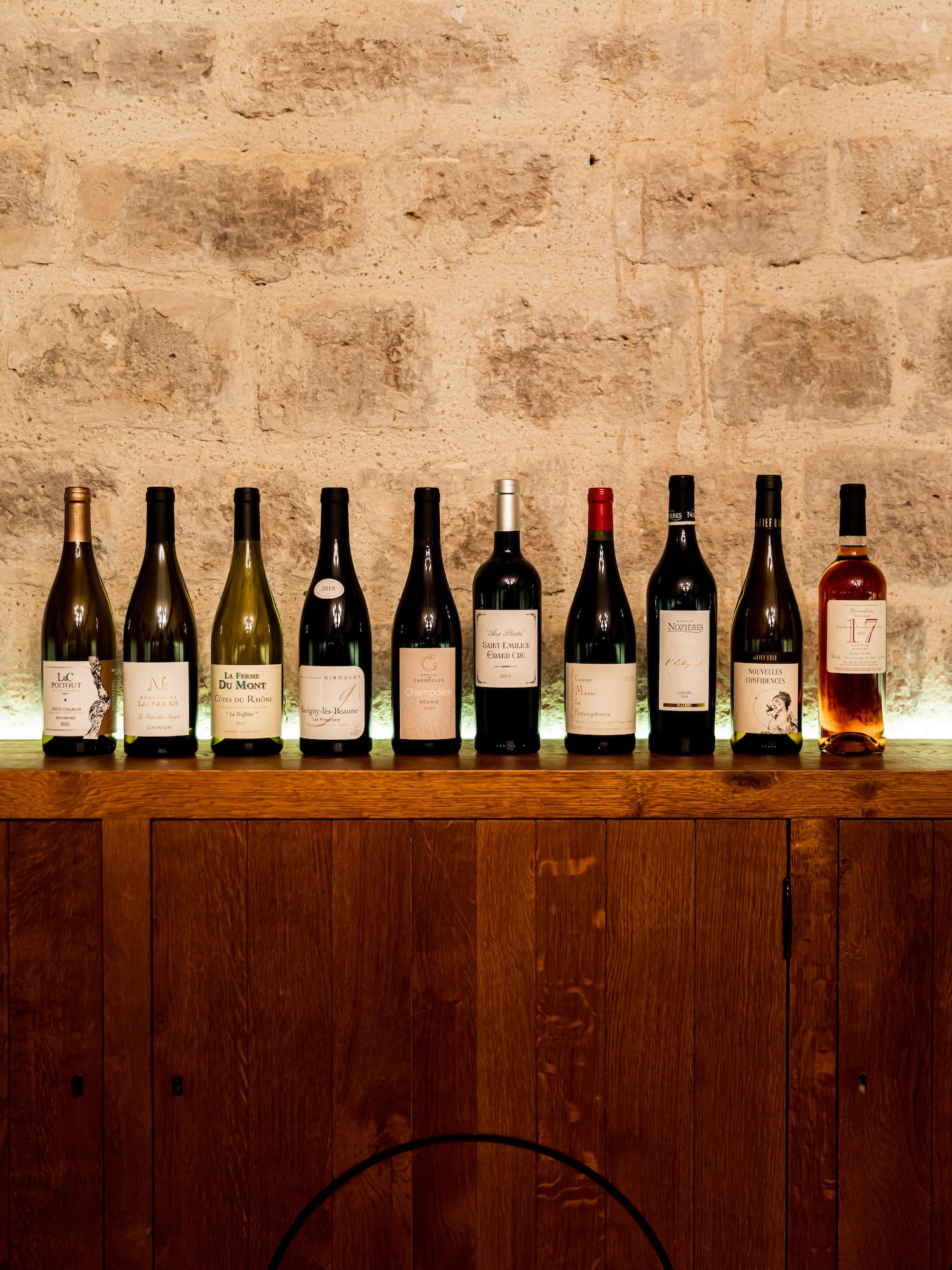 a row of wine bottles on a wooden shelf