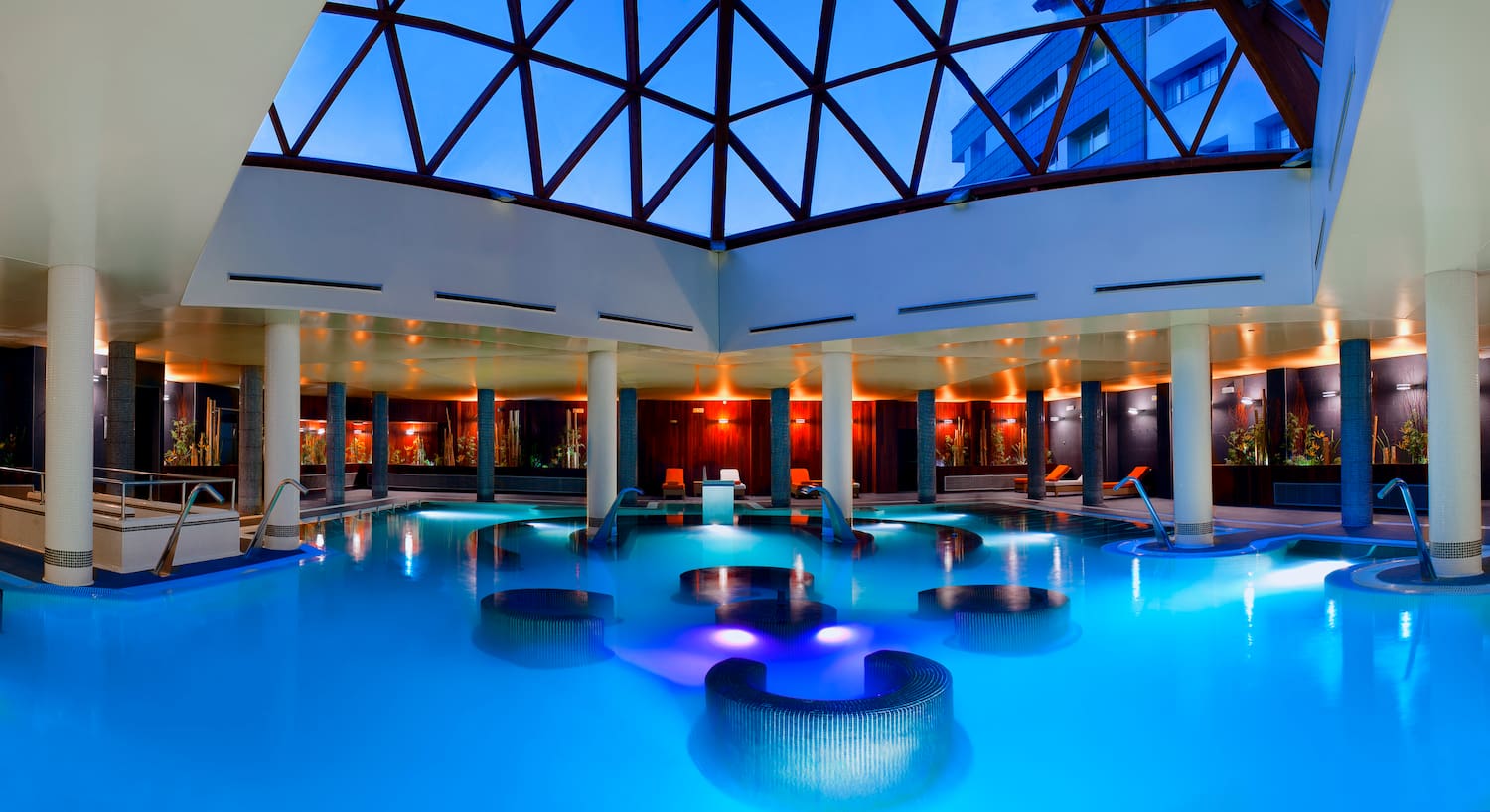 a indoor pool with chairs and a large window