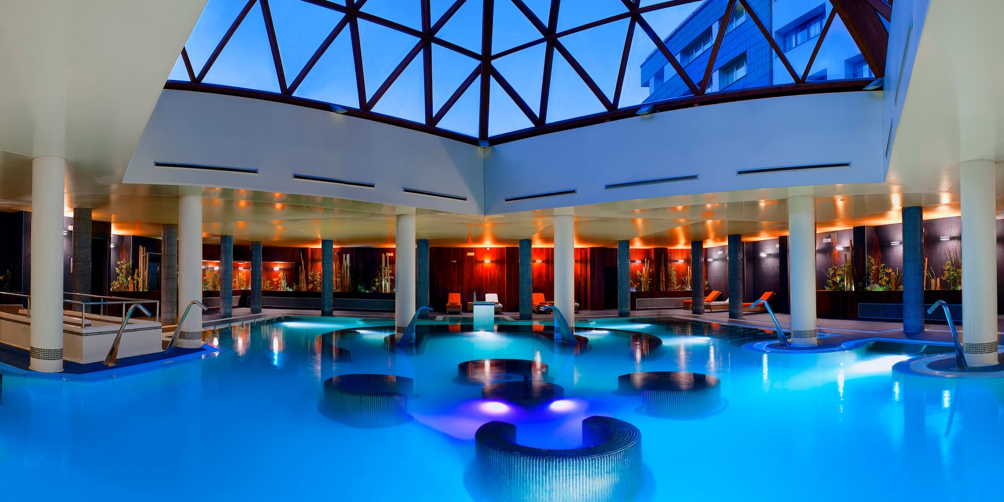 a pool with chairs and a glass roof