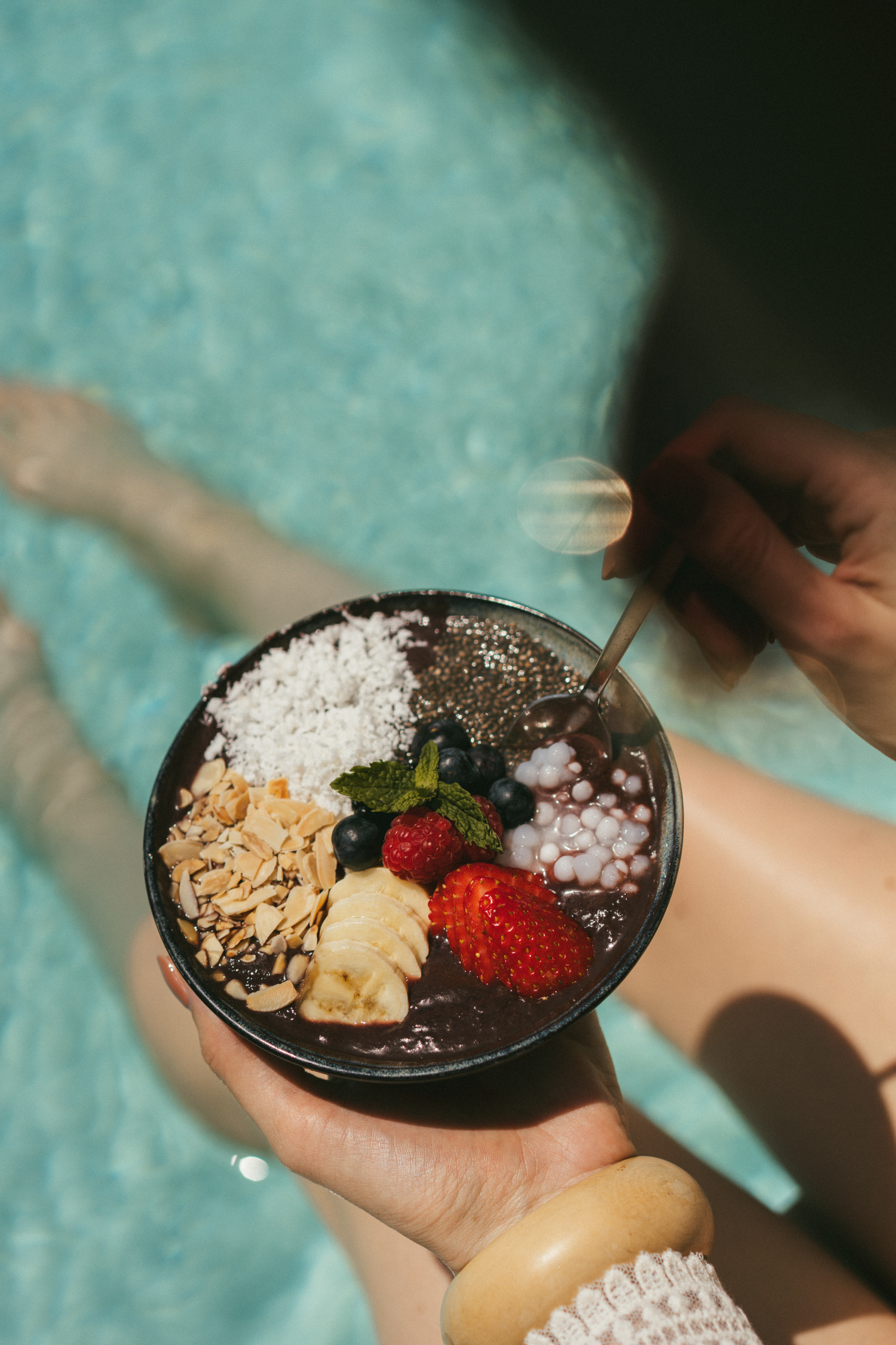 Acai bowl with fresh fruit, coconut, and chia seeds in a pool.