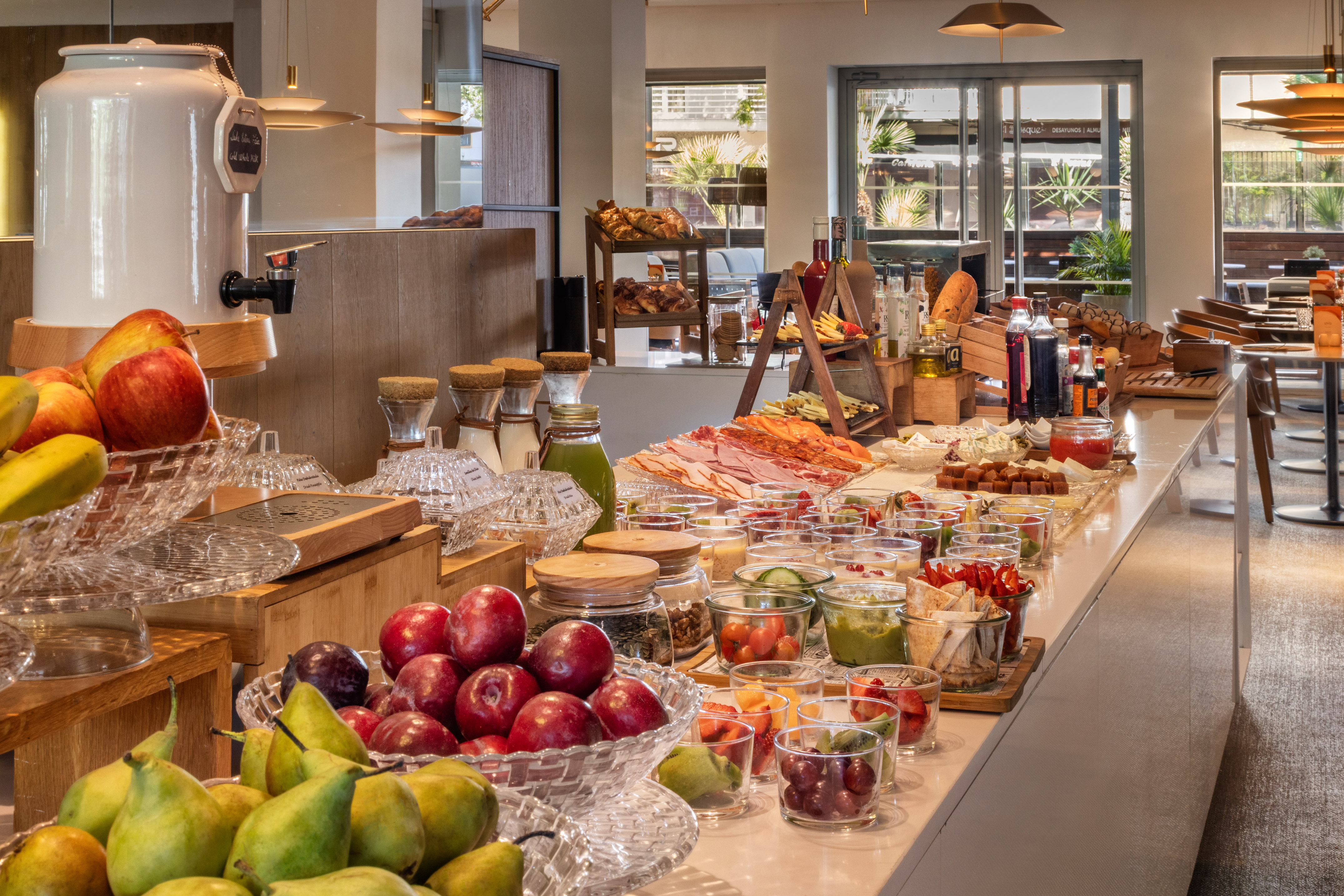 Abundant hotel breakfast buffet with fresh fruits, deli meats, cheese, pastries.