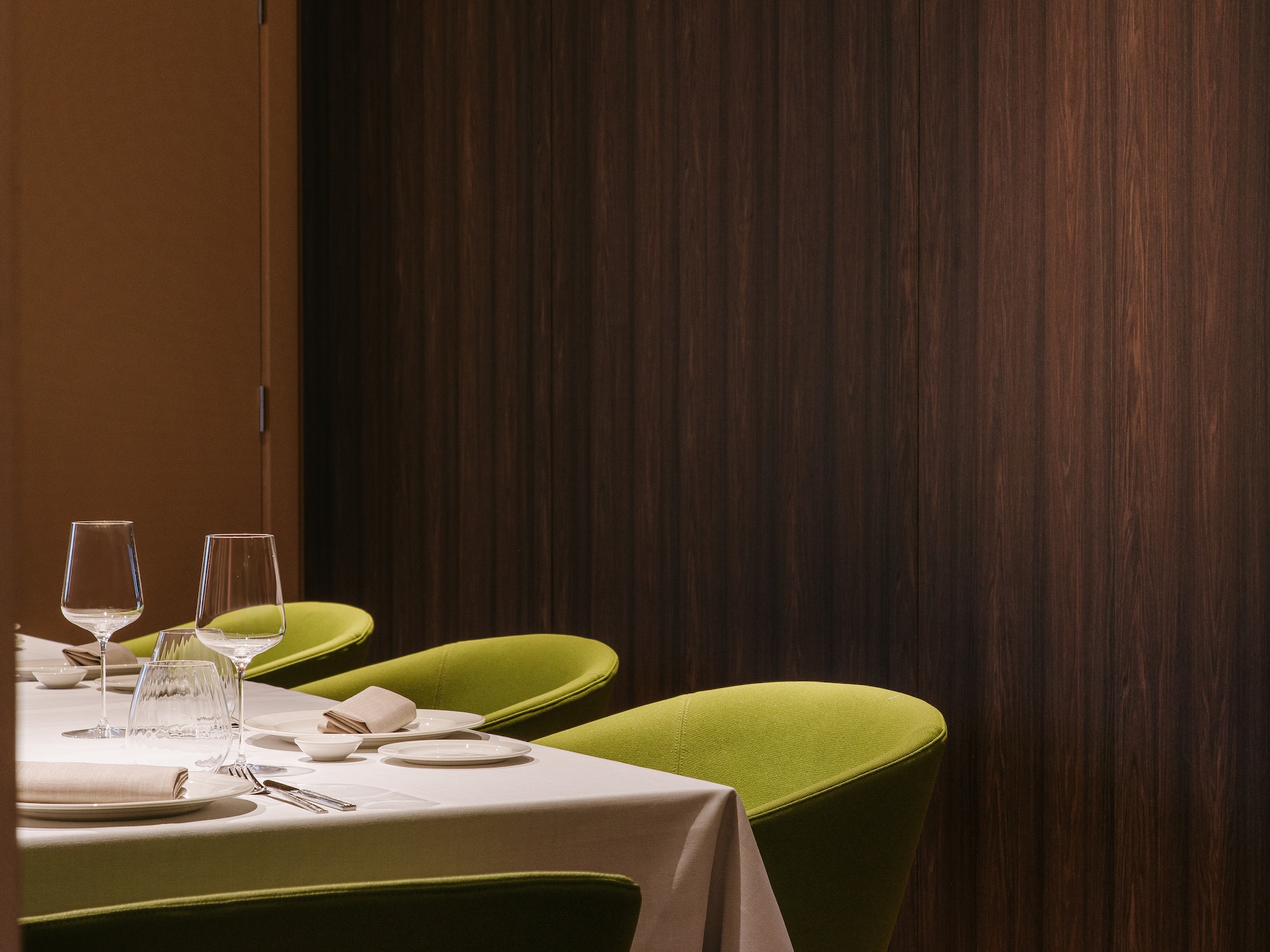 a table with green chairs and a white tablecloth