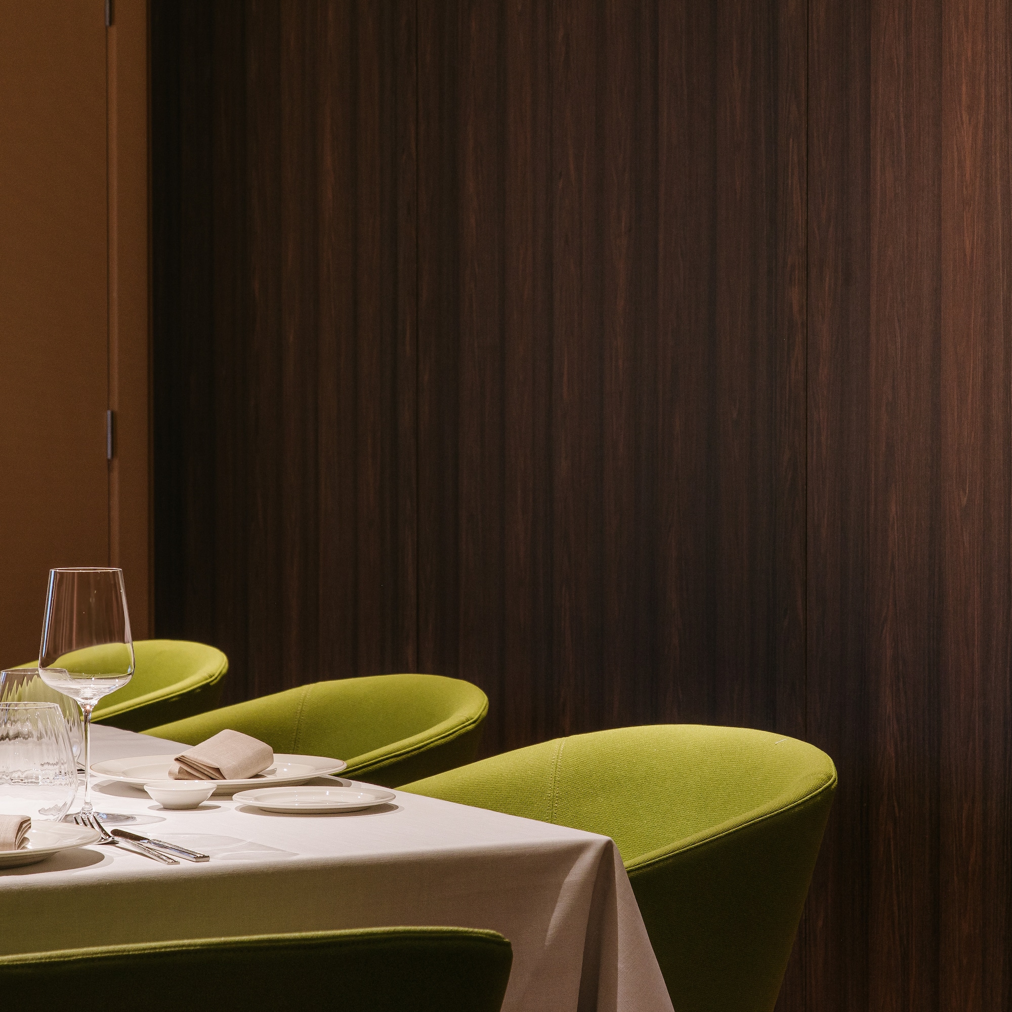 a table with green chairs and a white tablecloth