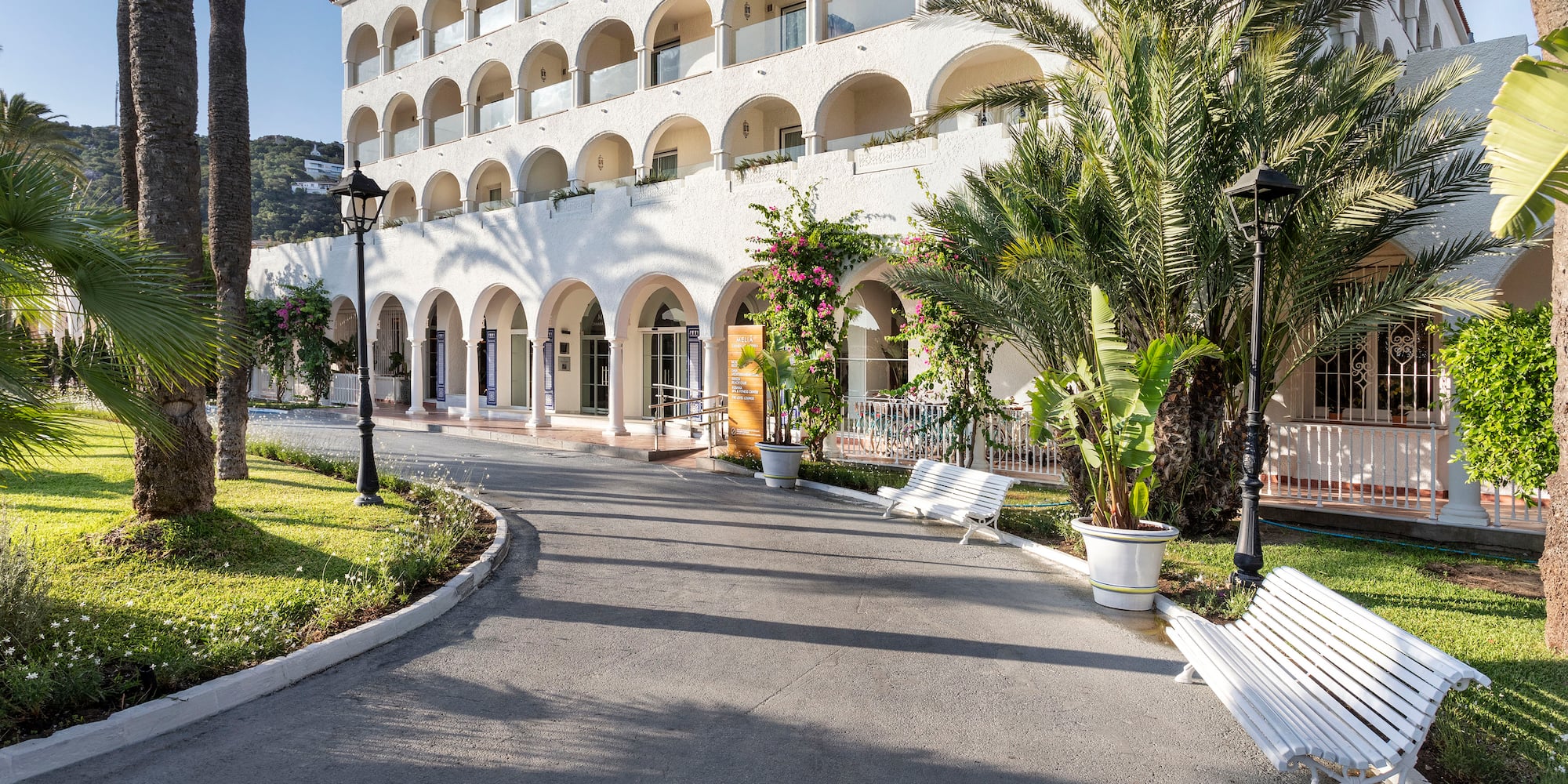 a white building with arches and palm trees