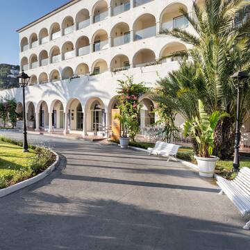 a white building with arches and palm trees