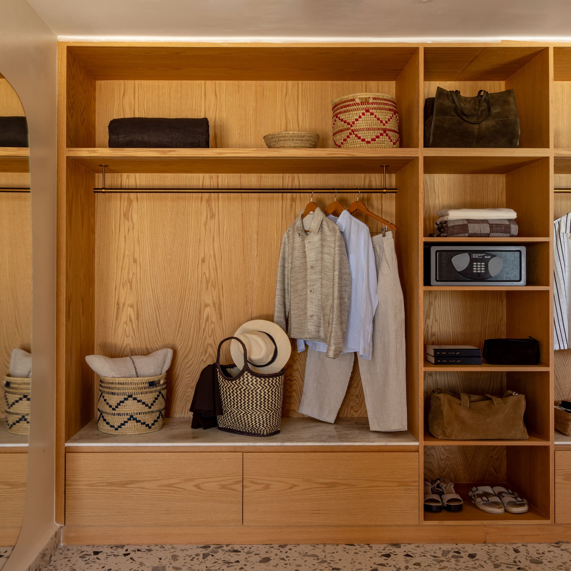 a closet with clothes and baskets