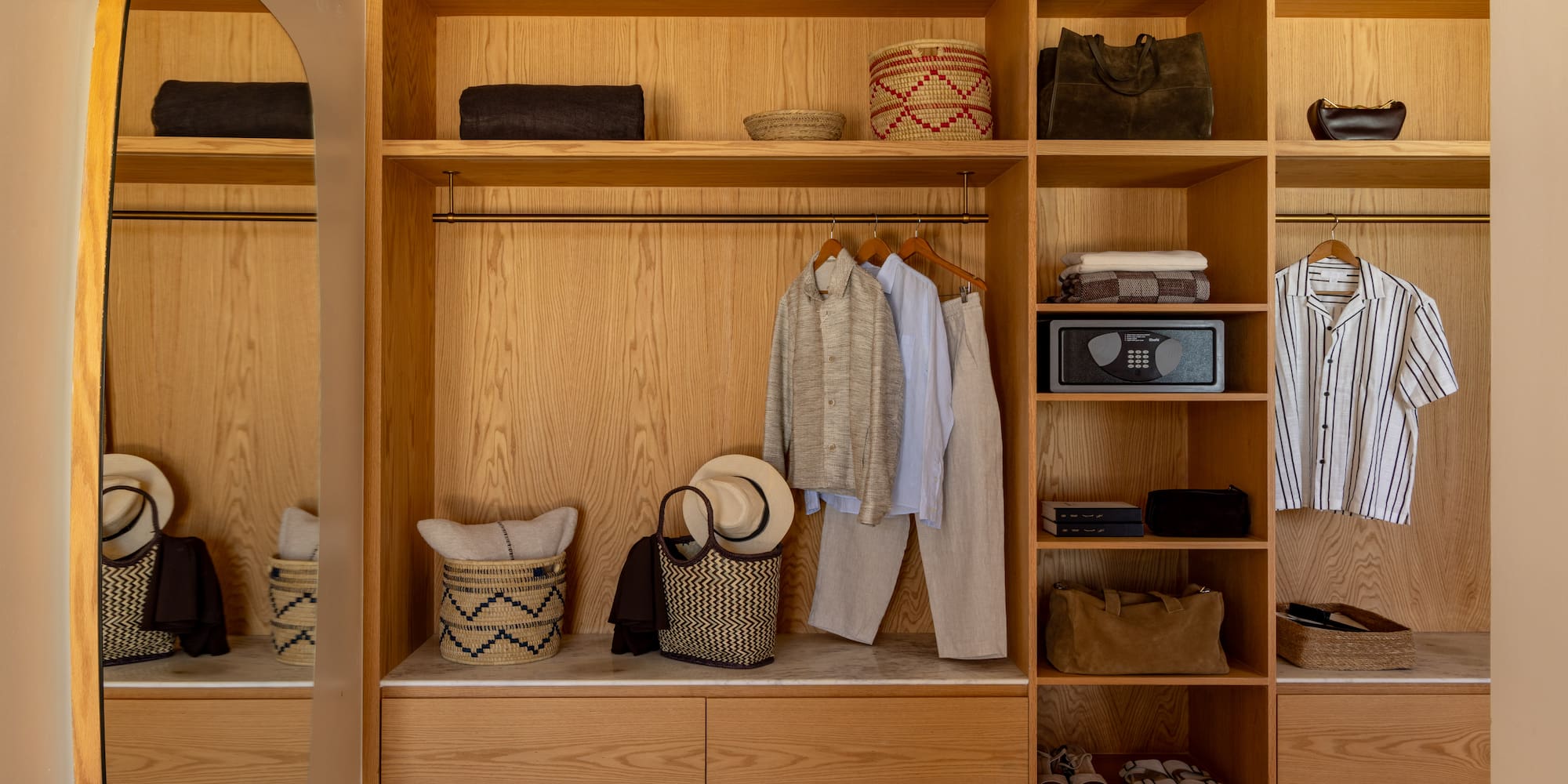 a closet with clothes and baskets