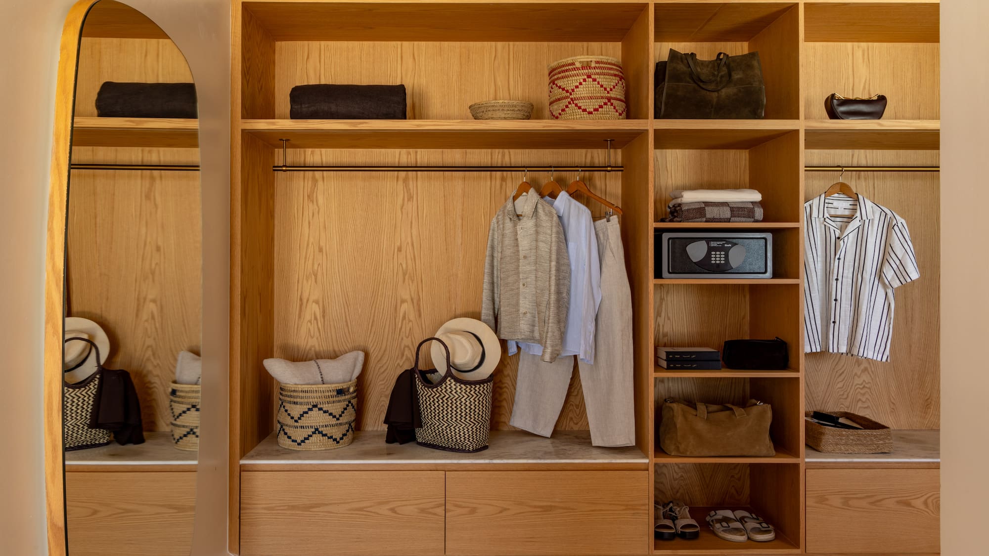 a closet with clothes and baskets