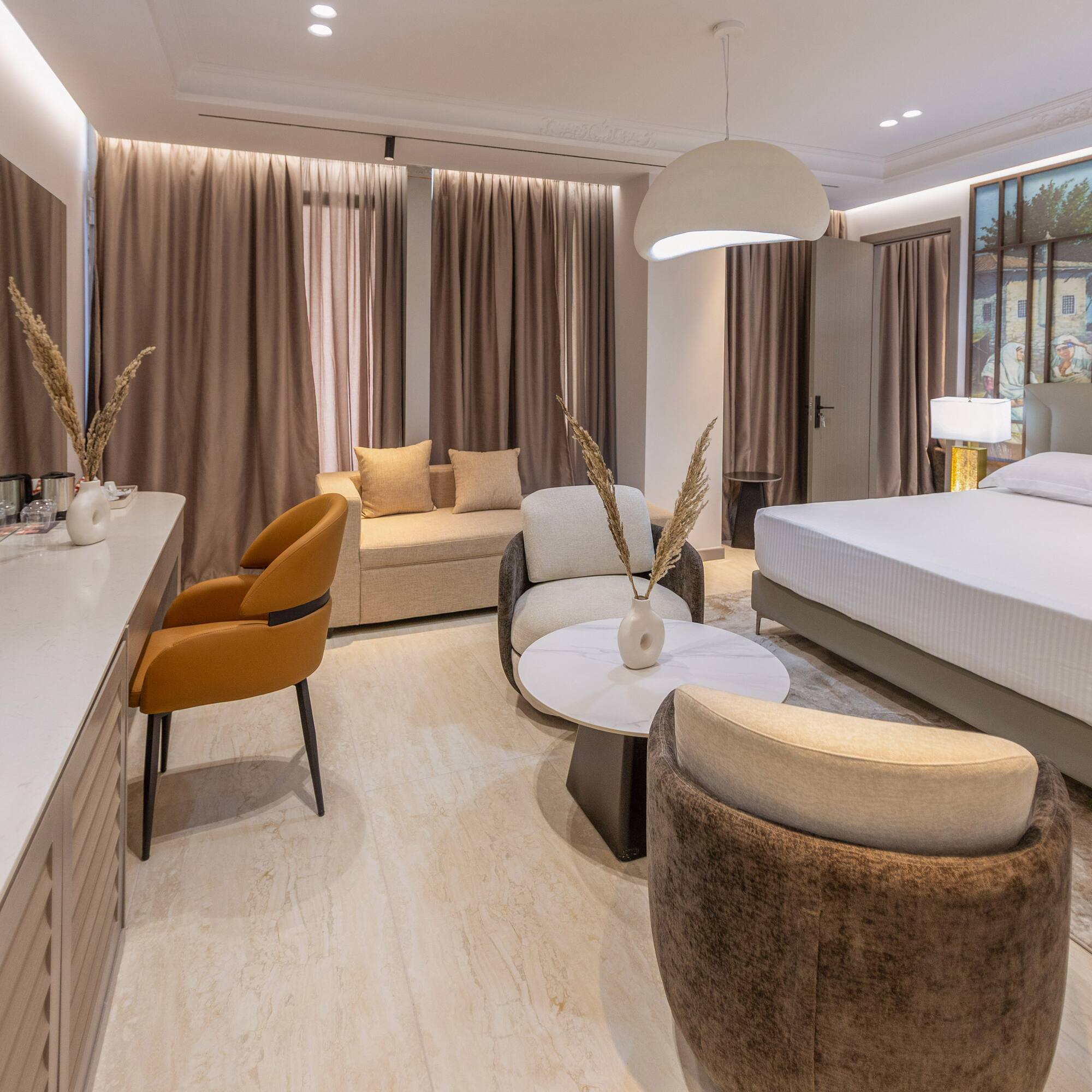 a room with a bed and chairs