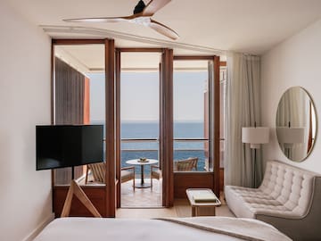 a room with a television and a view of the ocean