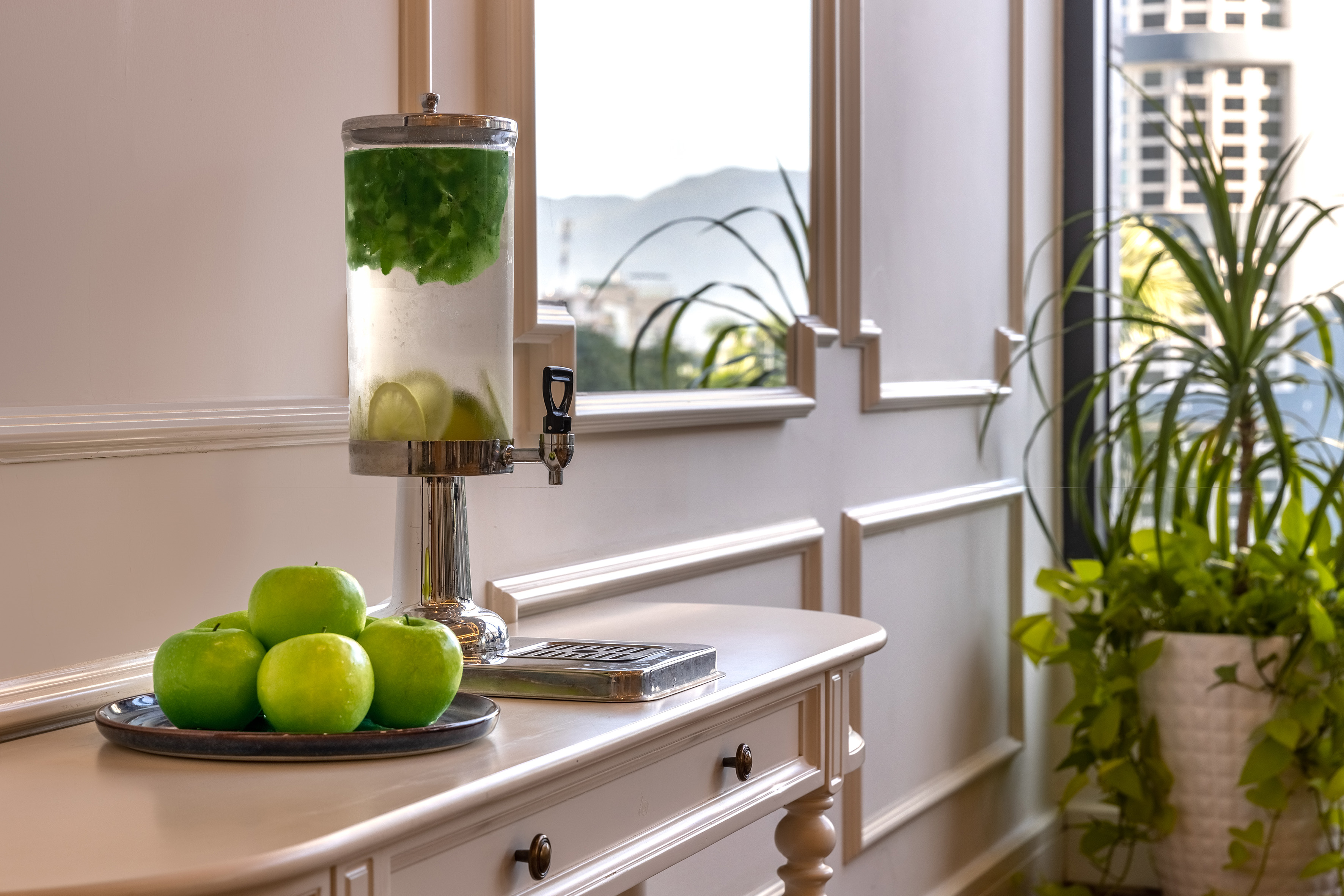 Hotel lobby refreshment station with infused water and green apples.