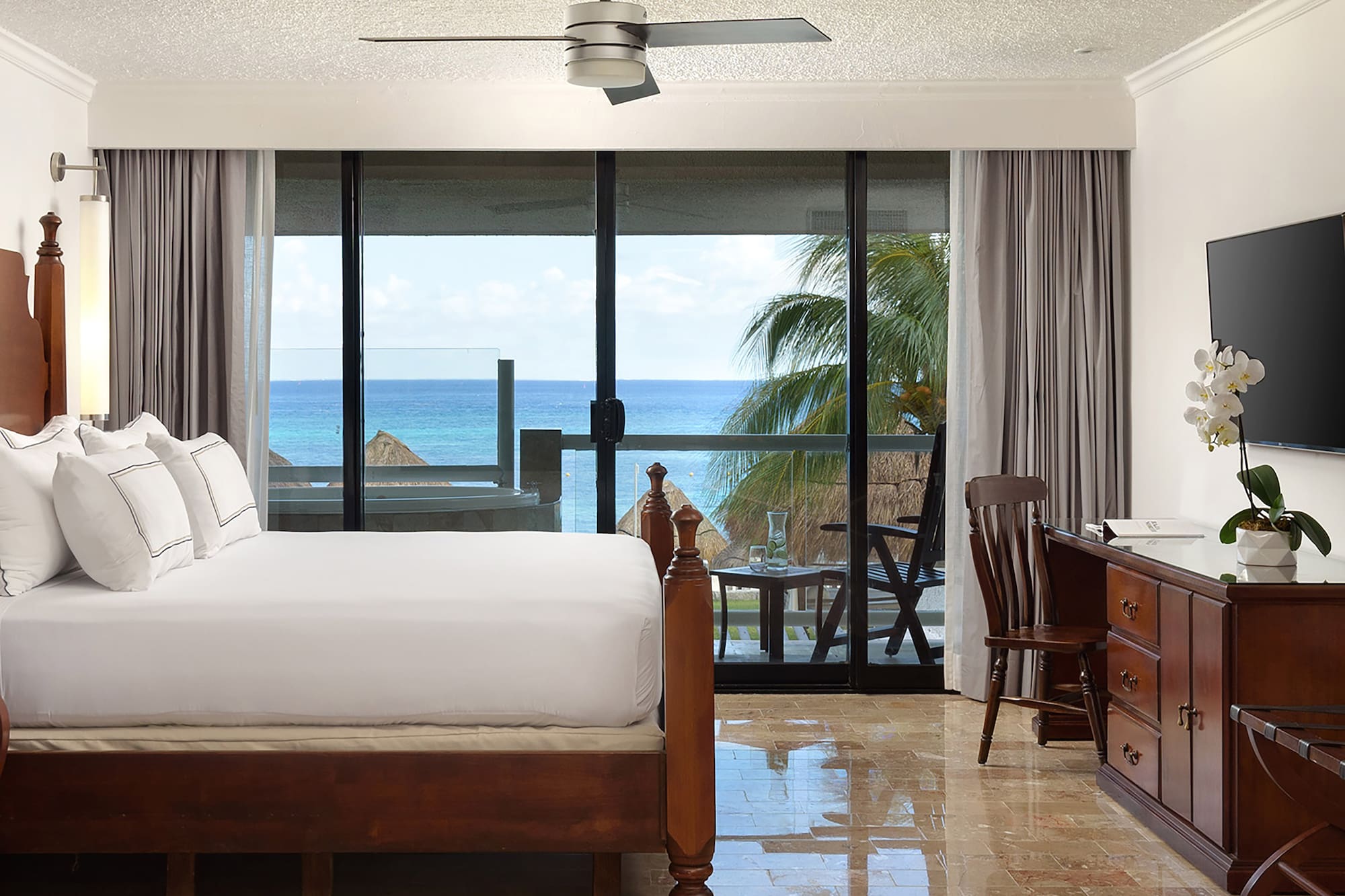 a bedroom with a large bed and a ceiling fan