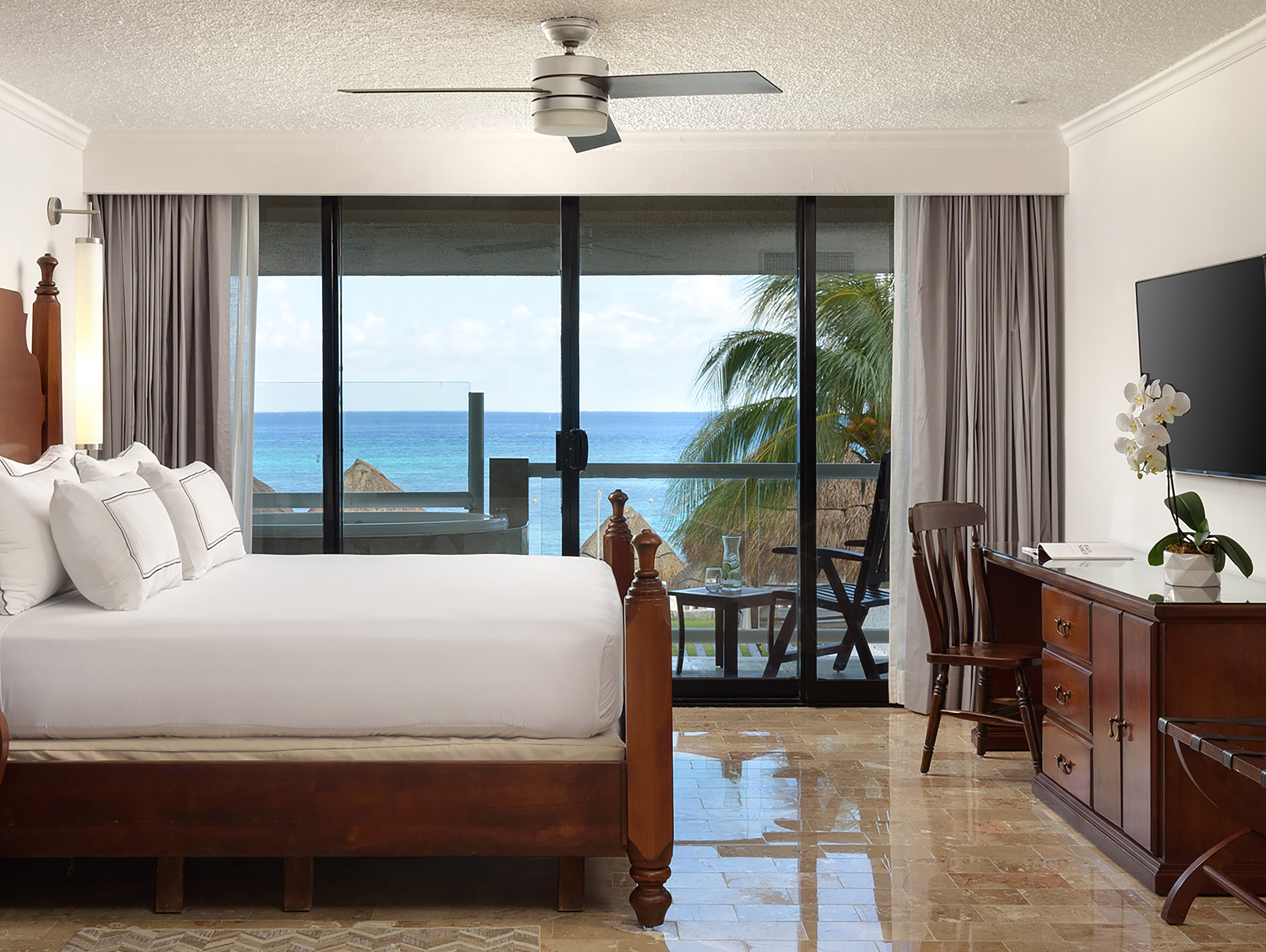 a bedroom with a large bed and a ceiling fan