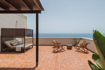 a deck with chairs and a fire pit on a sunny day