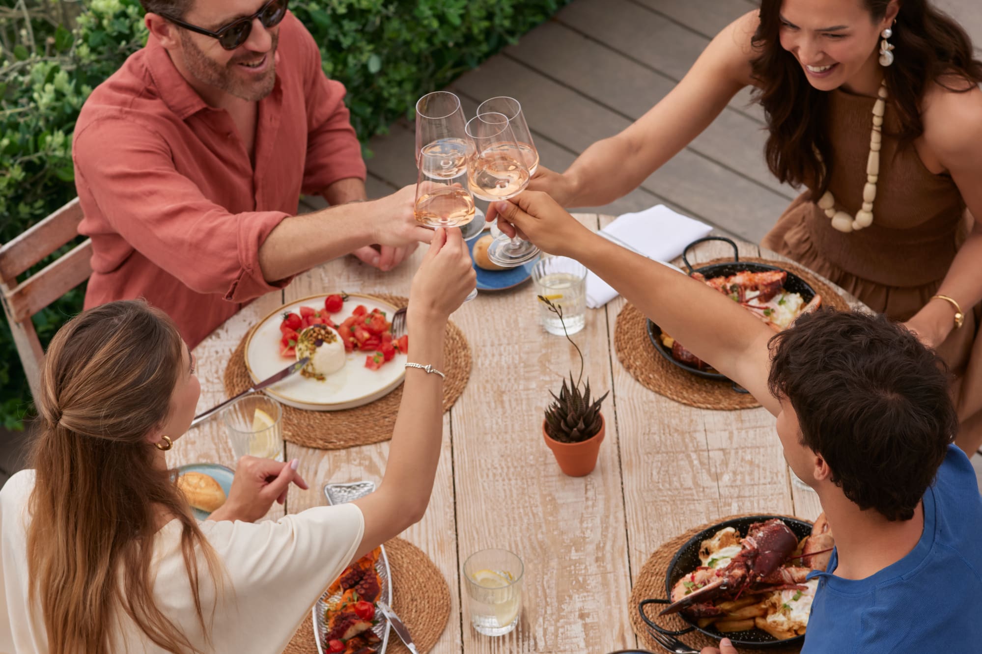 a group of people sitting around a table with food and drinks