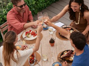 a group of people sitting around a table with food and drinks