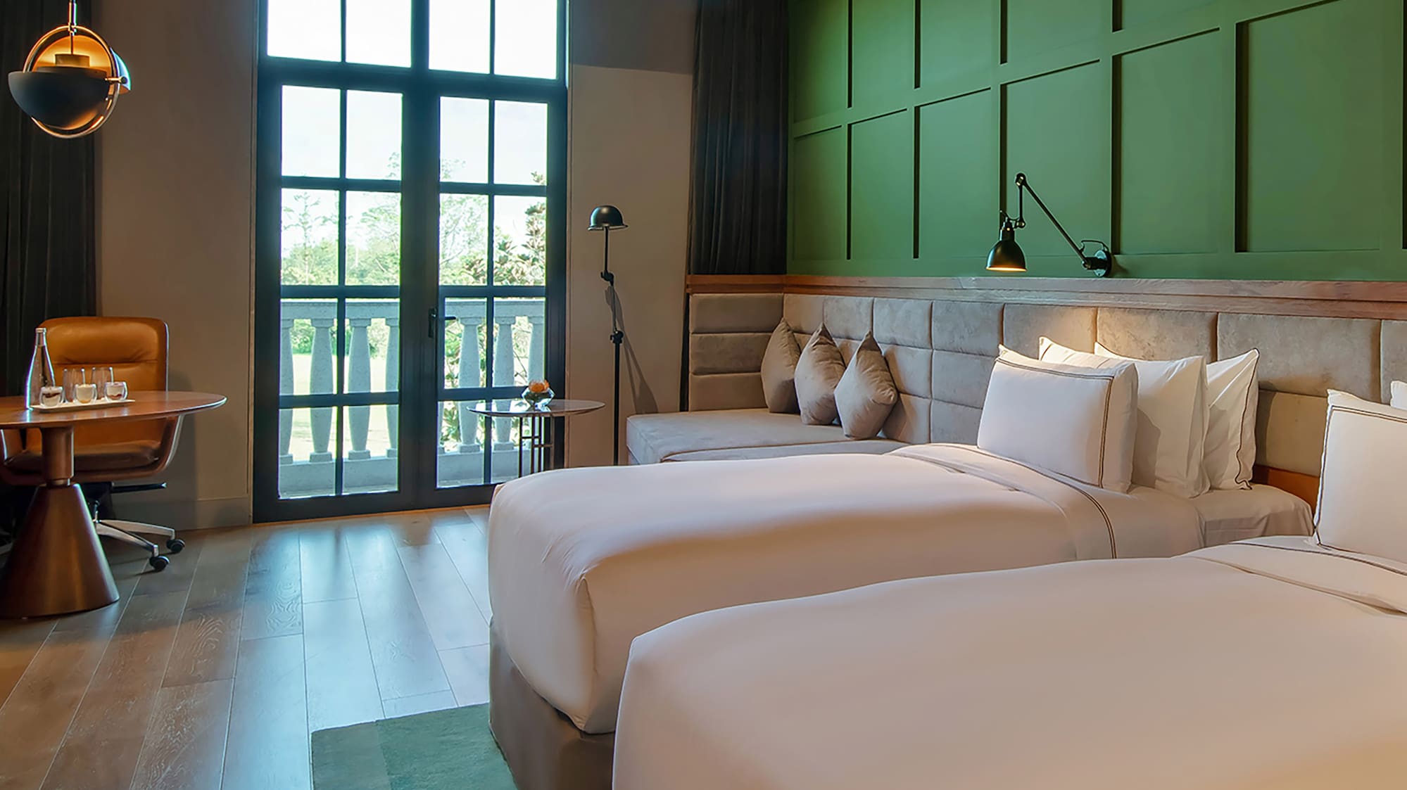 a room with two beds and a green wall