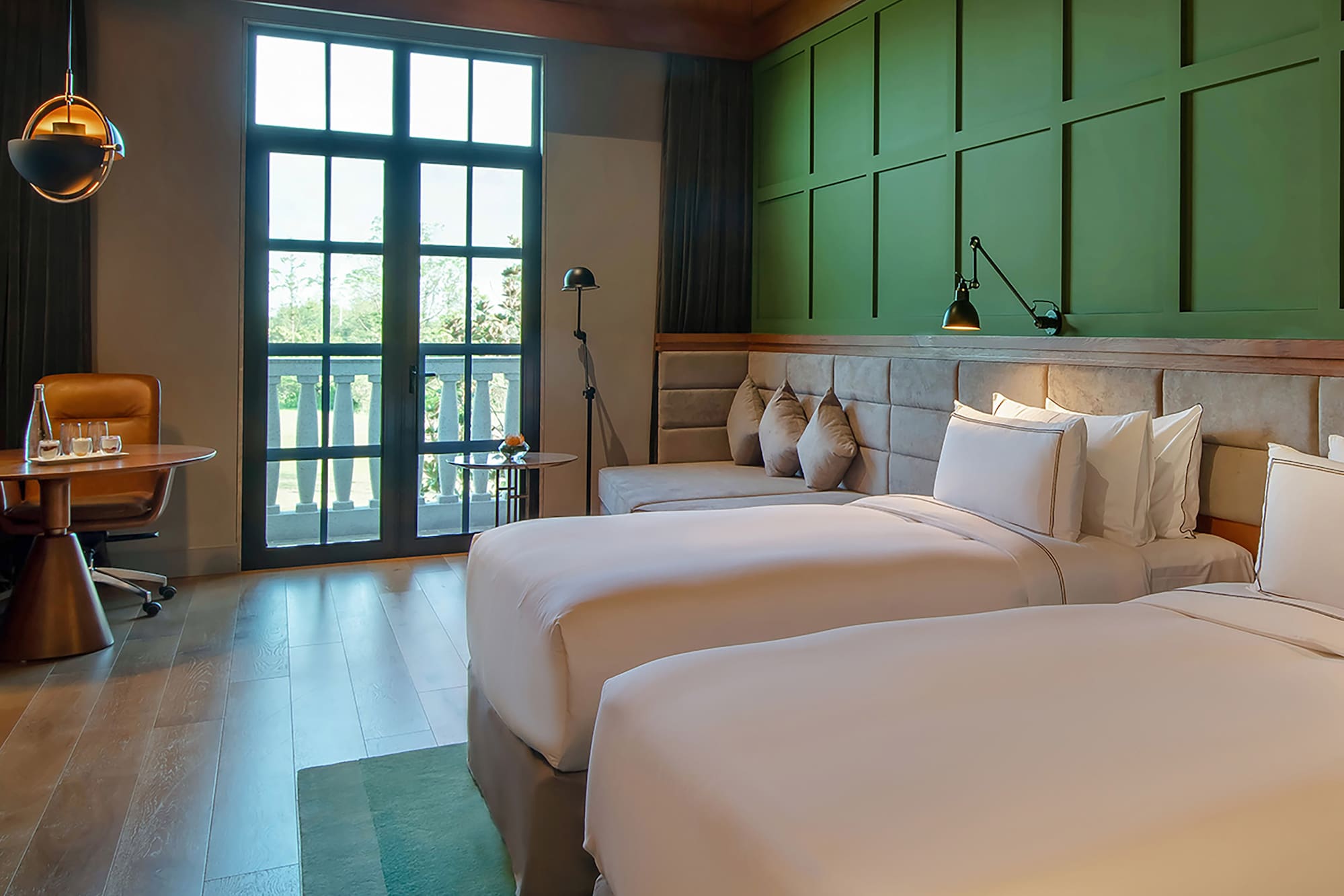 a room with two beds and a green wall