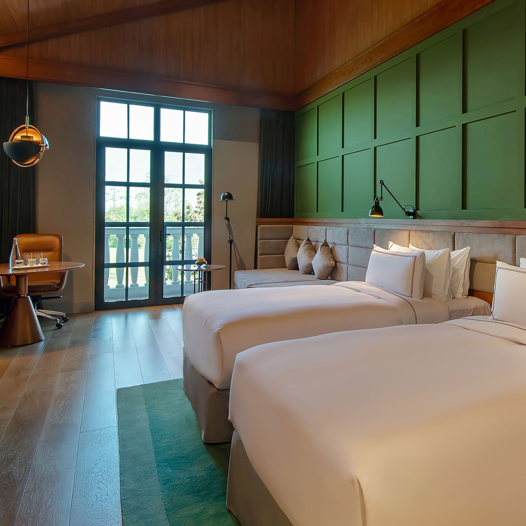 a room with two beds and a green wall