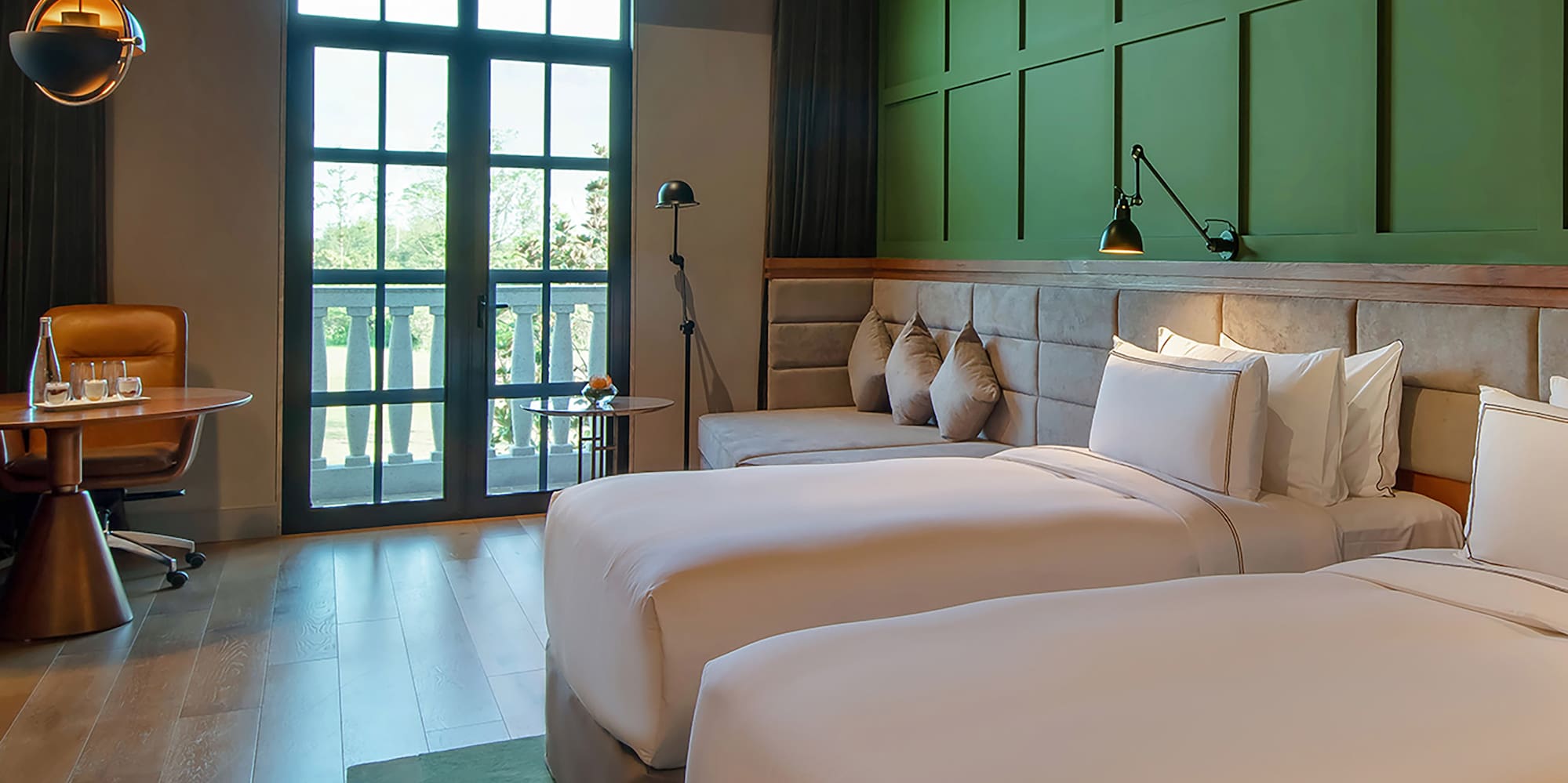 a room with two beds and a green wall