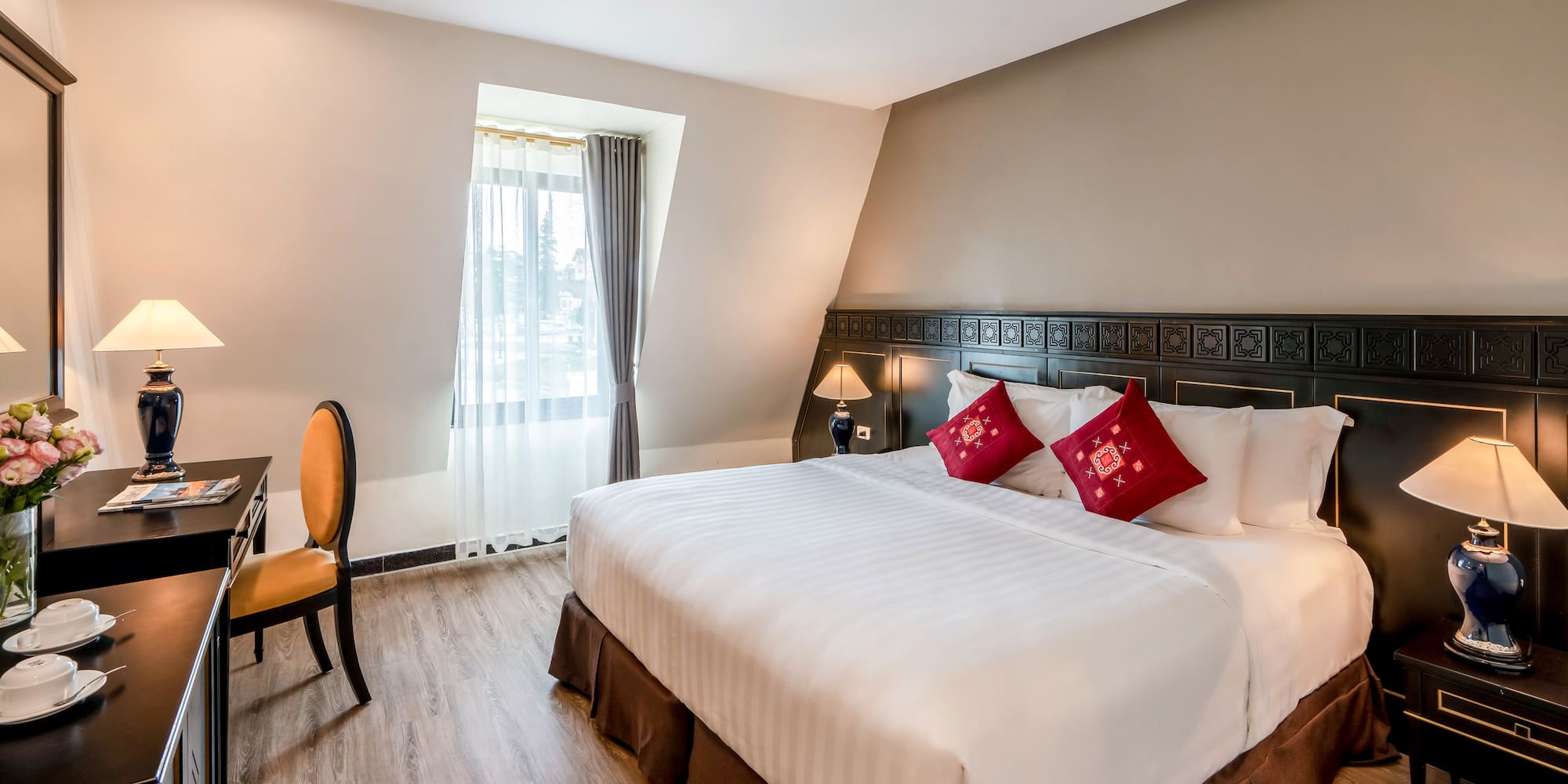 a bed with red pillows and a chair in a room