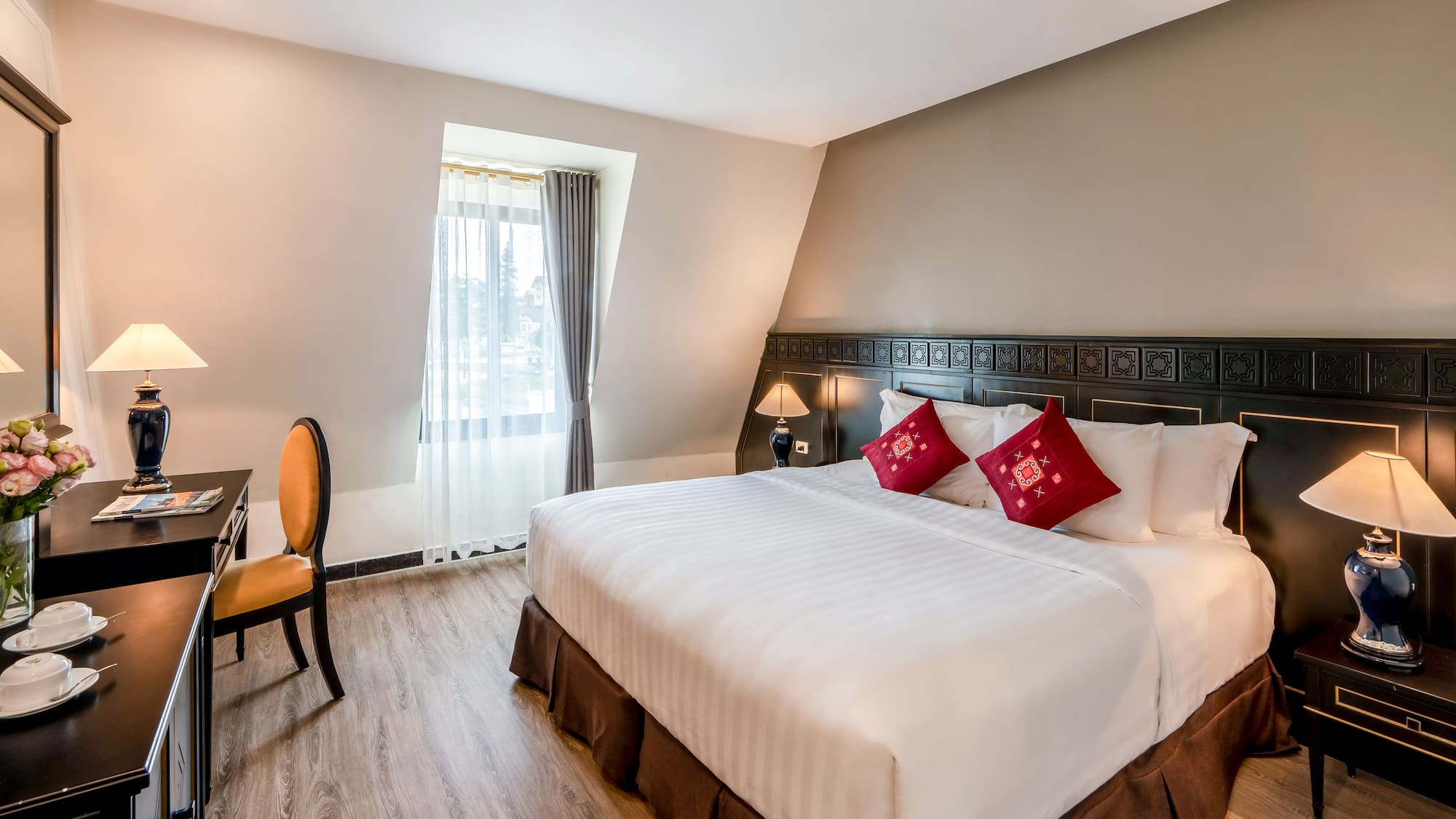 a bed with red pillows and a chair in a room