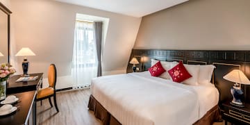 a bed with red pillows and a chair in a room