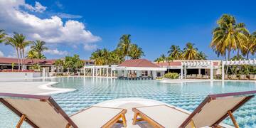 a pool with lounge chairs and palm trees