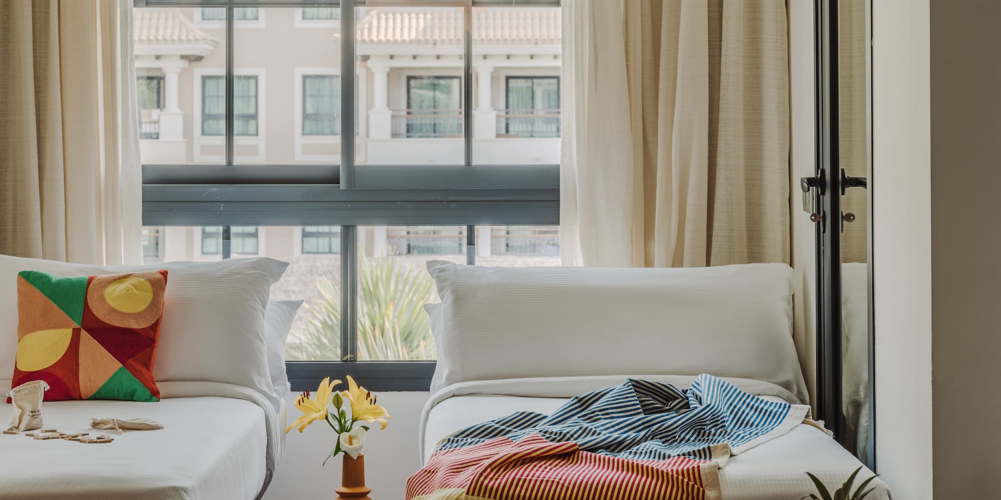 a room with two beds and a table with a lamp