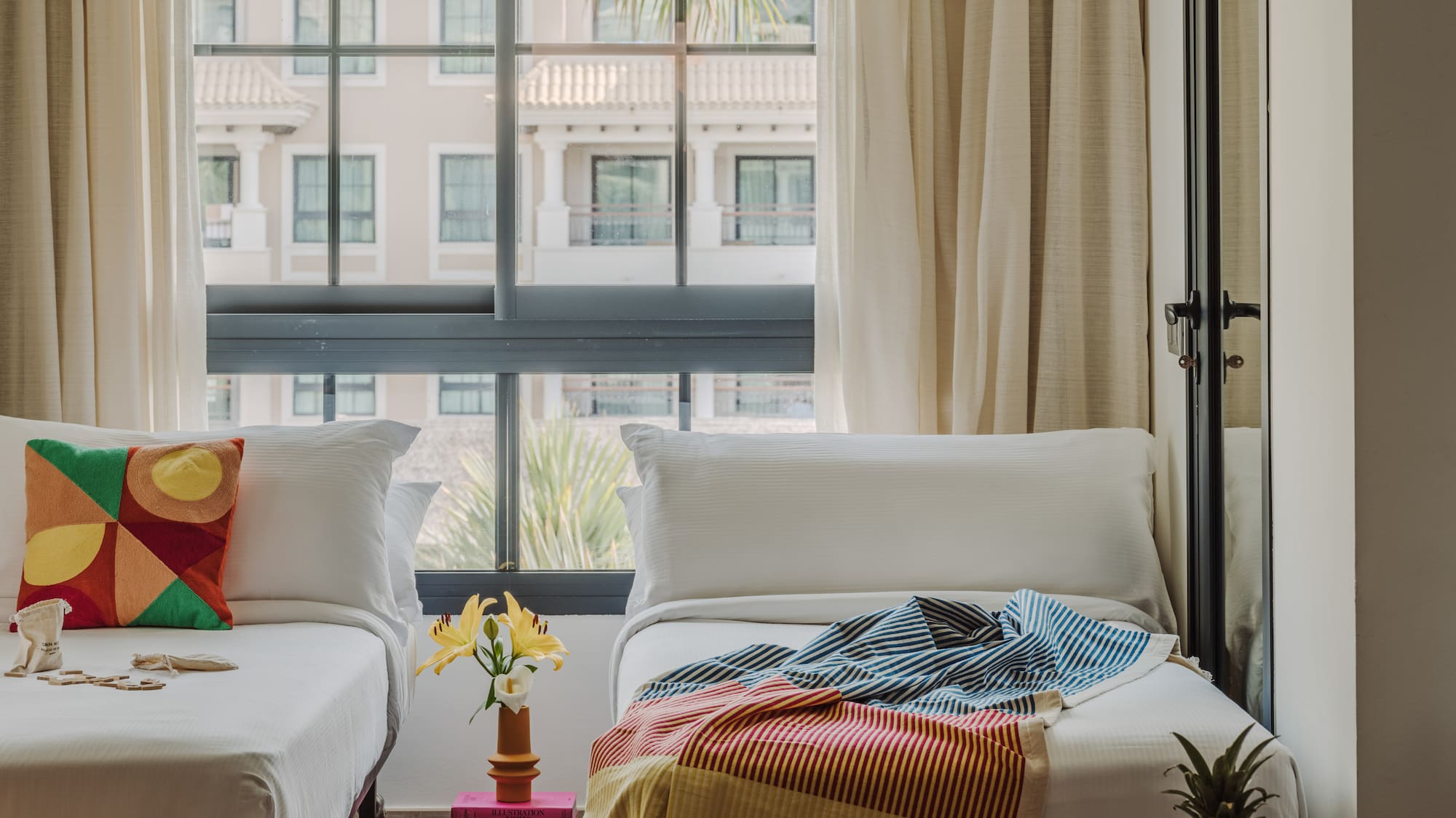 a room with two beds and a table with a lamp