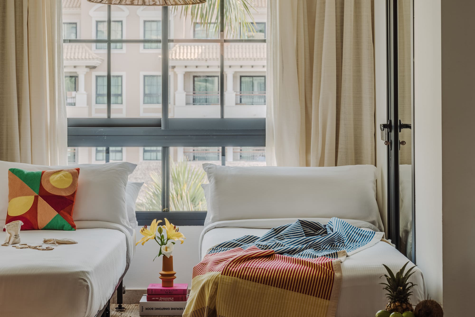 a room with two beds and a table with a lamp