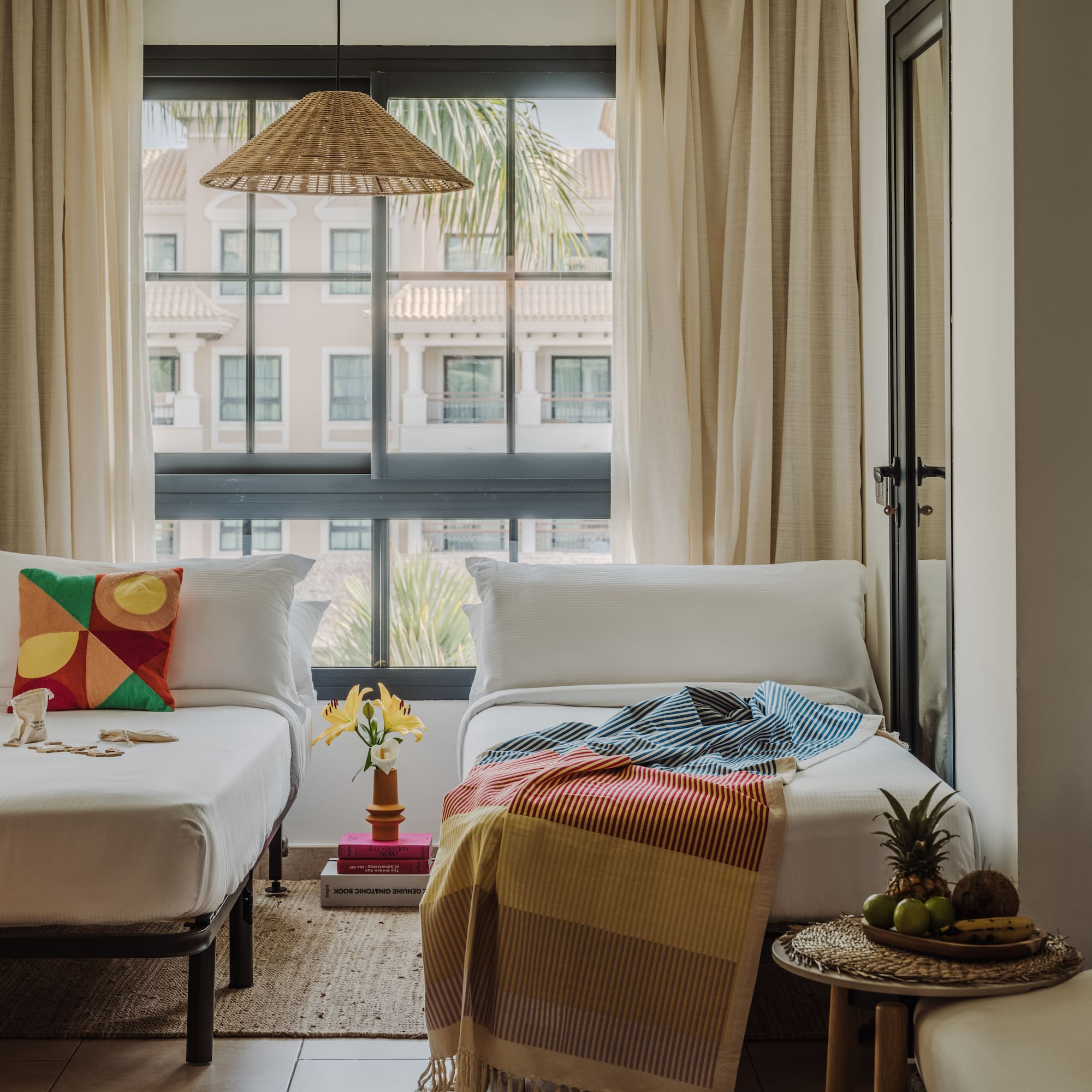 a room with two beds and a table with a lamp