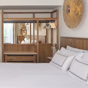 a bed with white sheets and a mirror above it