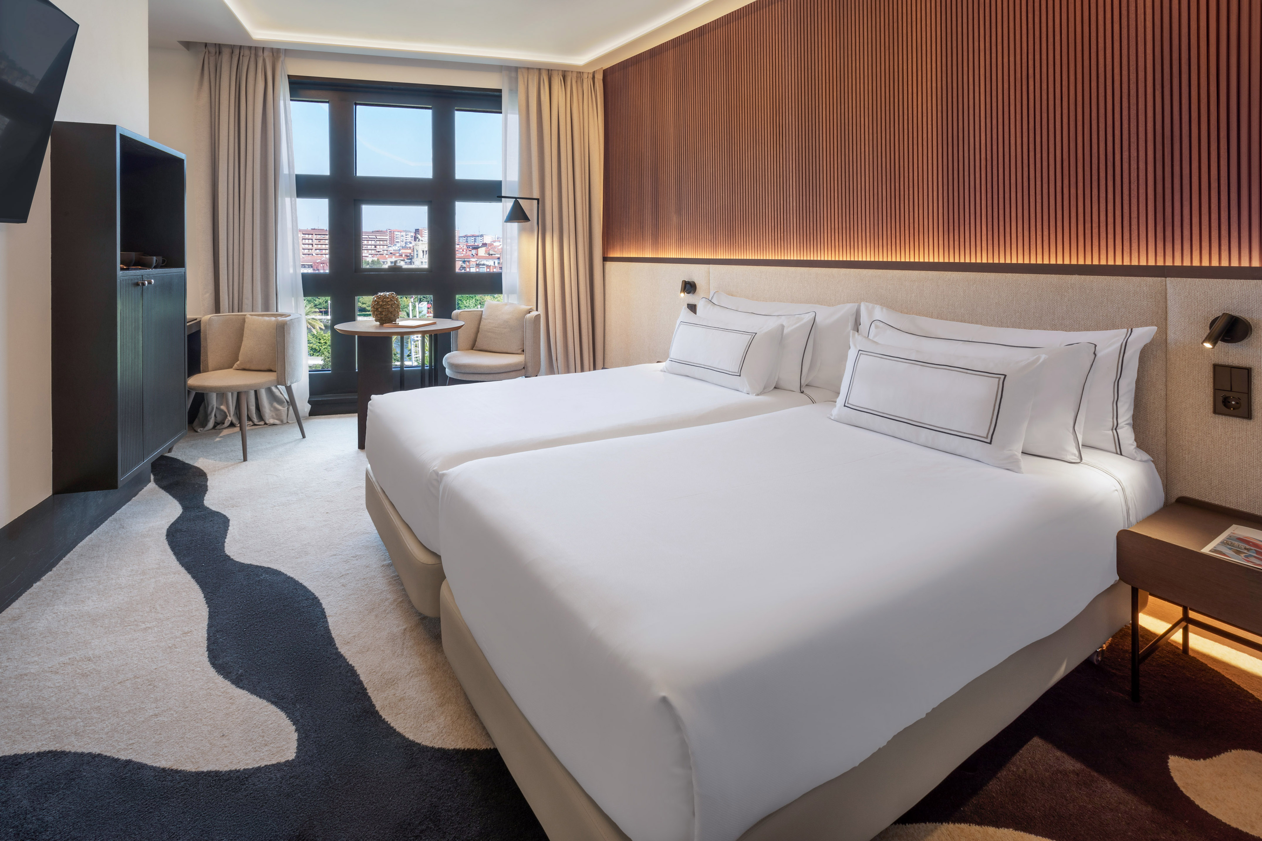 a room with two beds and a table and chairs