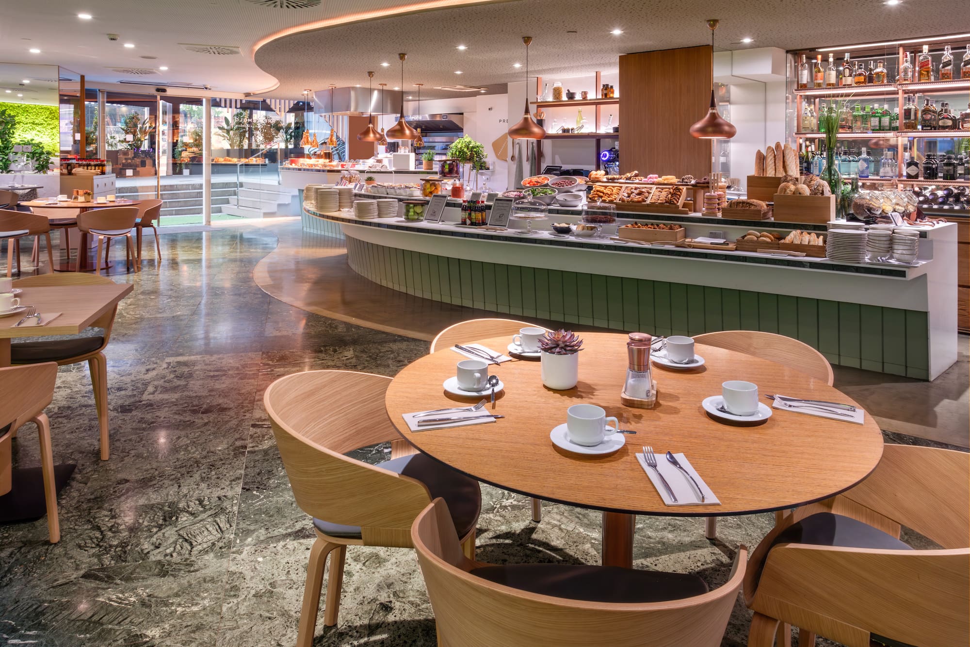 Modern hotel restaurant with a full breakfast buffet and elegant dining area.