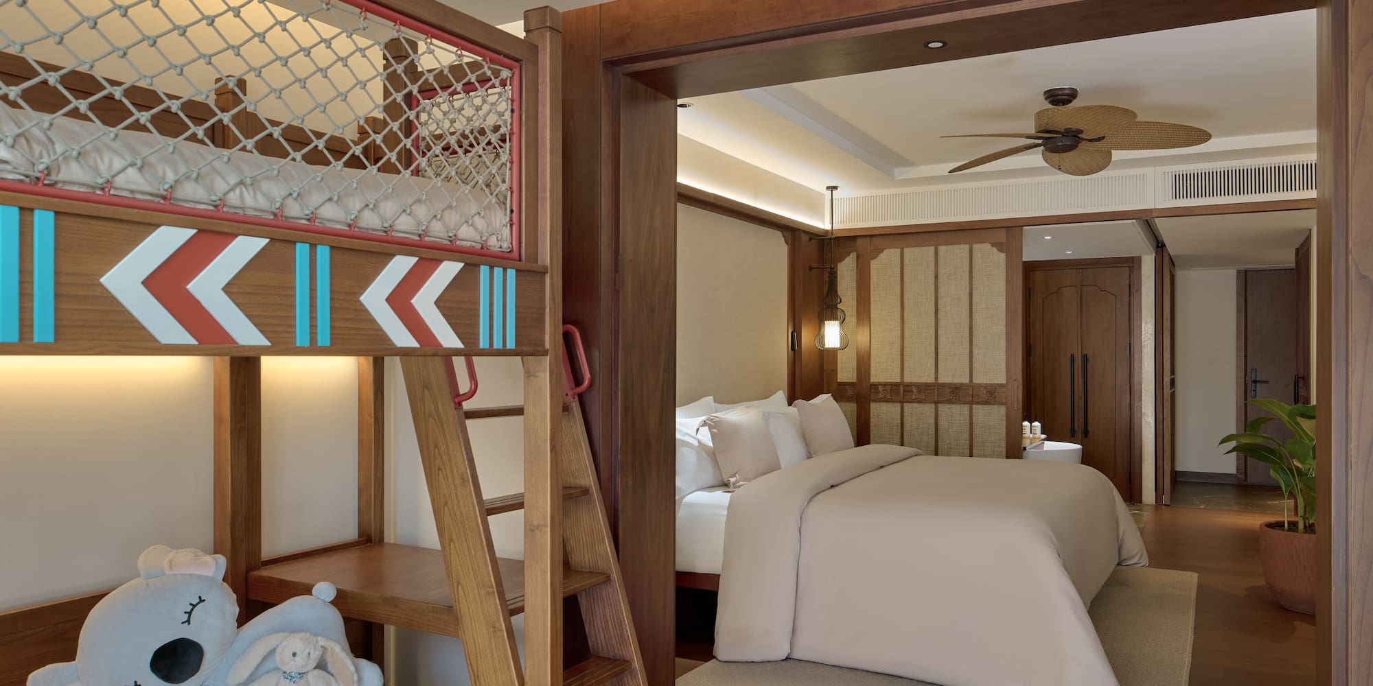 a room with bunk beds and a bed with a ladder