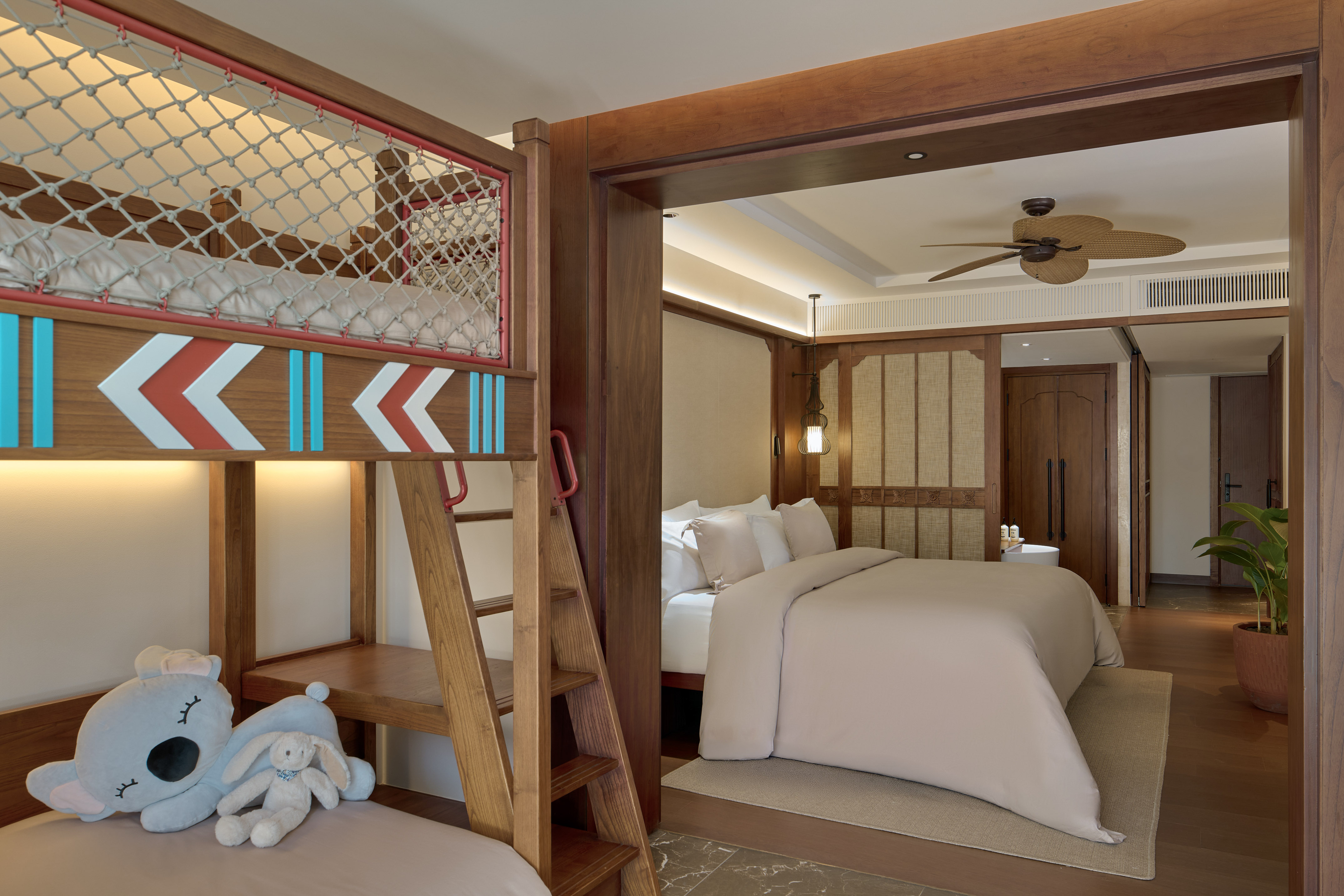 a room with bunk beds and a bed with a ladder