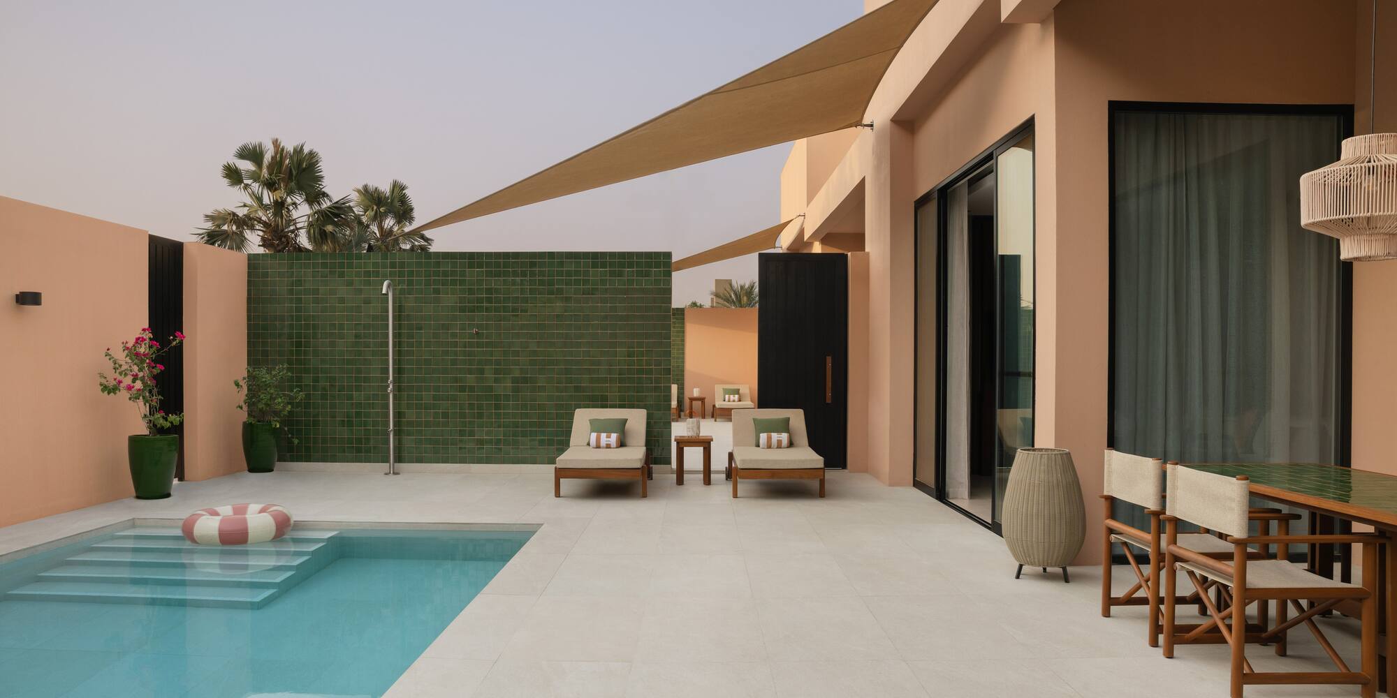 a pool and chairs outside of a house