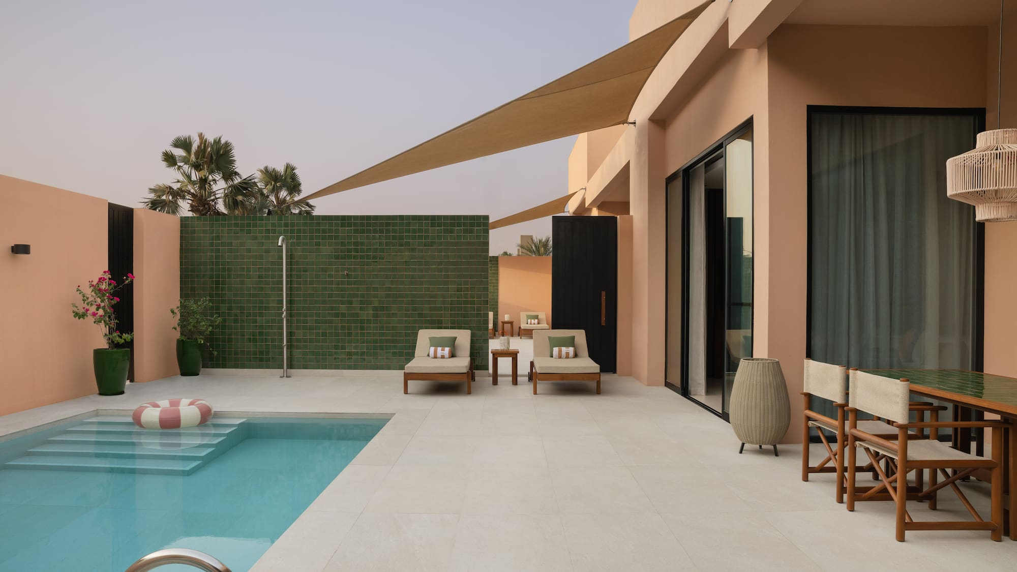 a pool and chairs outside of a house