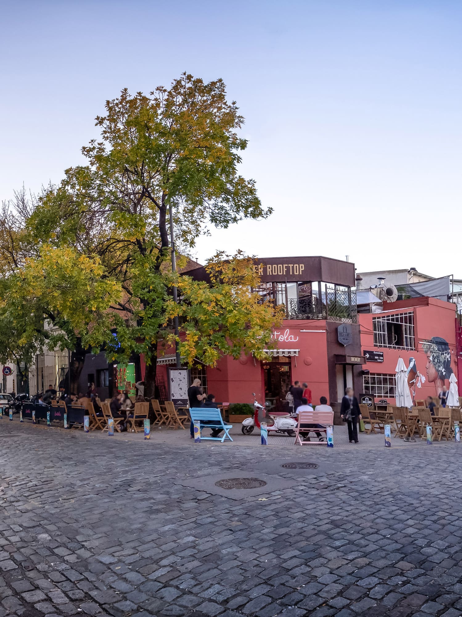 a street with chairs and tables in front of buildings