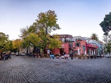 a street with chairs and tables in front of buildings