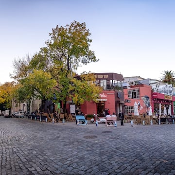 a street with chairs and tables in front of buildings