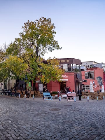 a street with chairs and tables in front of buildings